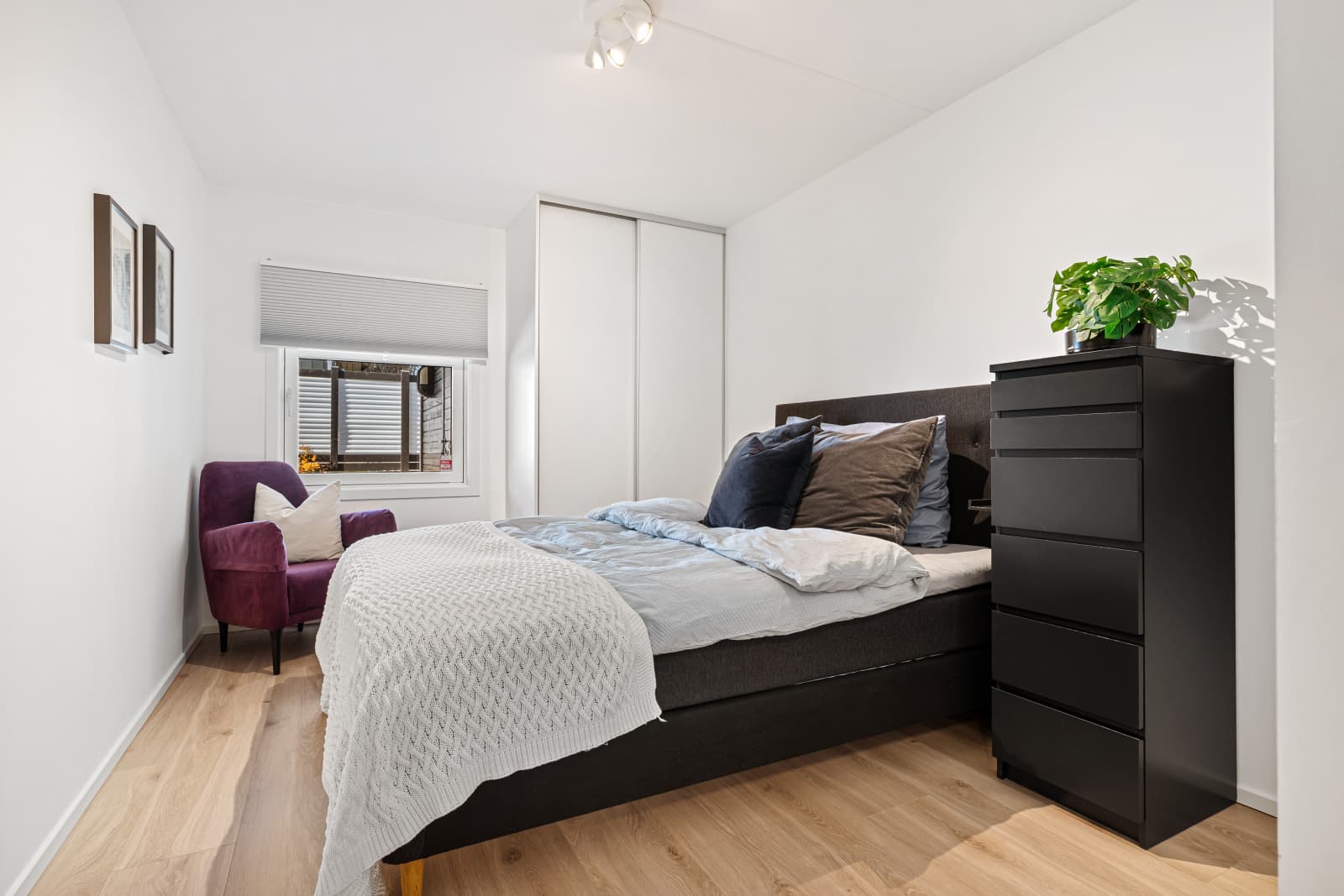 Romslig hovedsoverom med en gjennomtenkt og funksjonell løsning, hvor dobbeltsengen er elegant plassert mellom to praktiske skyvedørsgarderober – én på hver side. Dette gir både god oppbevaringsplass og et ryddig uttrykk.