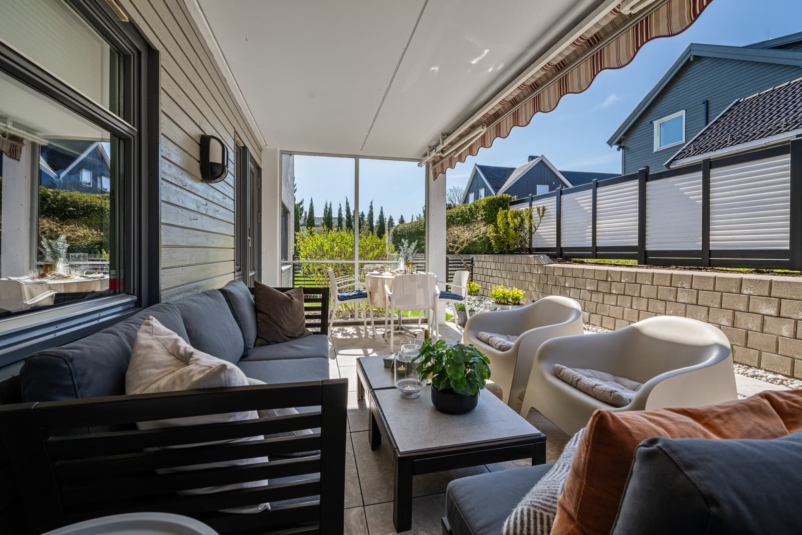 Romslig og overbygget uteplass med god plass til både lounge og spisegruppe – perfekt for lange sommerkvelder.
