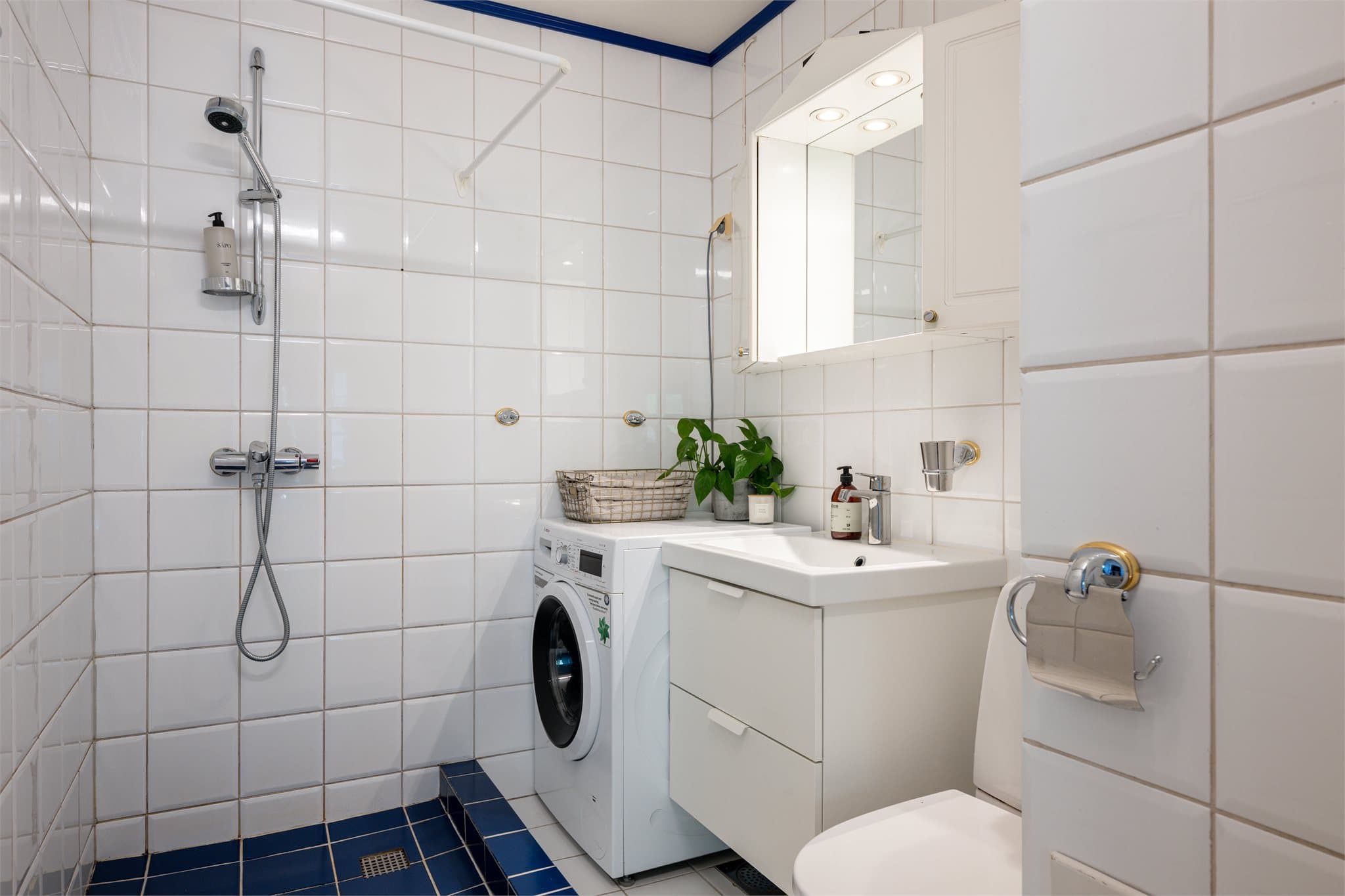 Flislagt bad med elektrisk gulvvarme og opplegg for vaskemaskin.