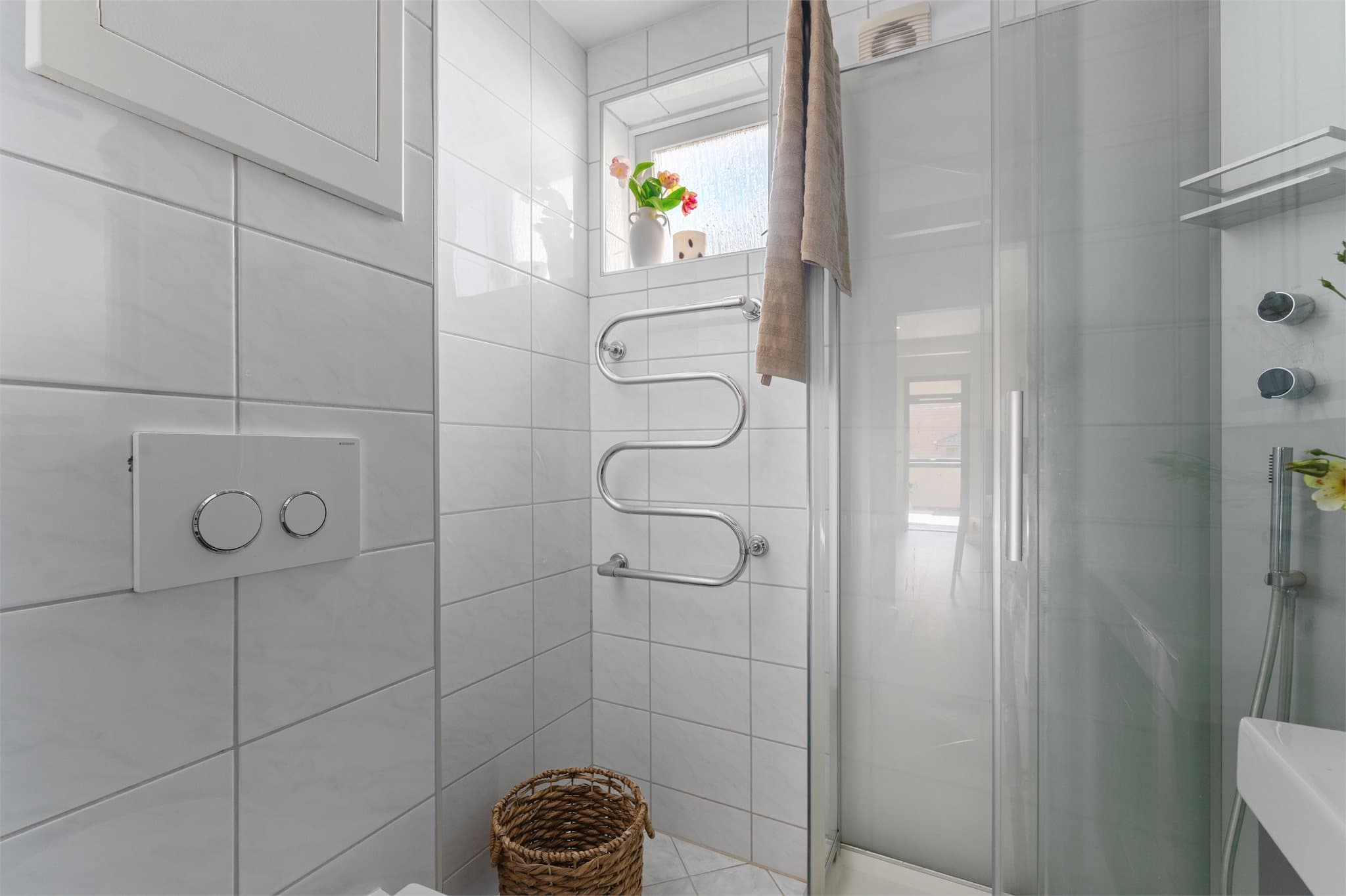- Badet er innredet med heldekkende servant, speilskap med belysning, vegghengt toalett og dusjkabinett -