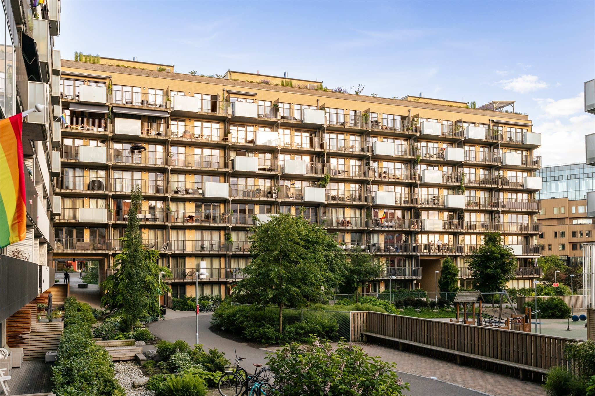 Store, bilfrie gårdsrom med lekeplasser, sittegrupper og beplantning.