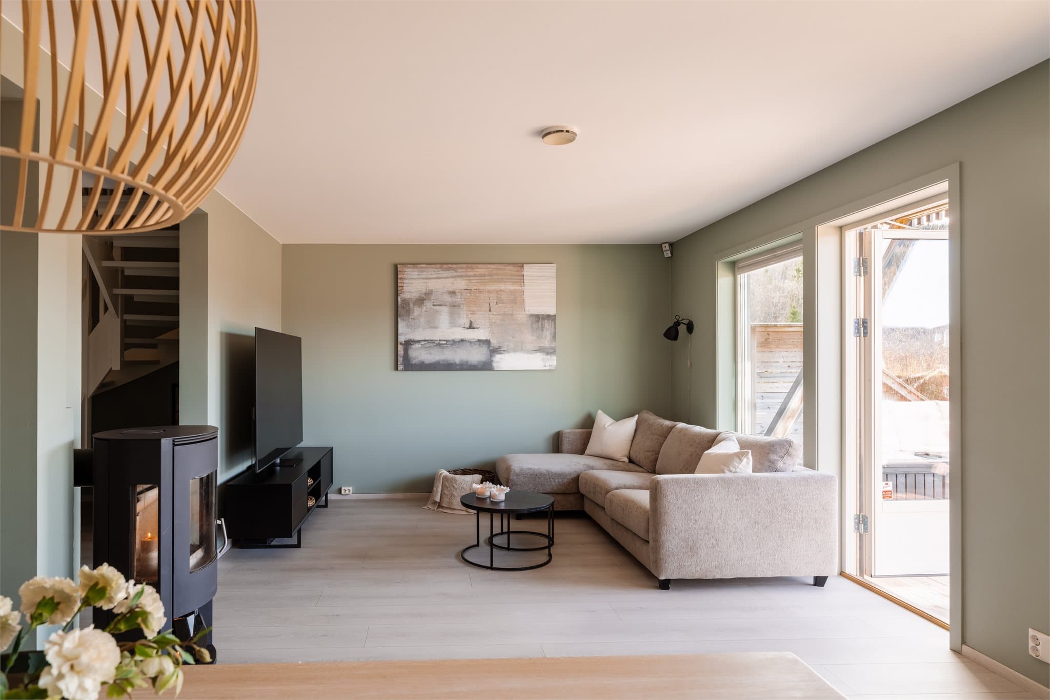 Rommet har naturlige soner for innredning, og har plass til en koselig sofakrok med tv-møblement.