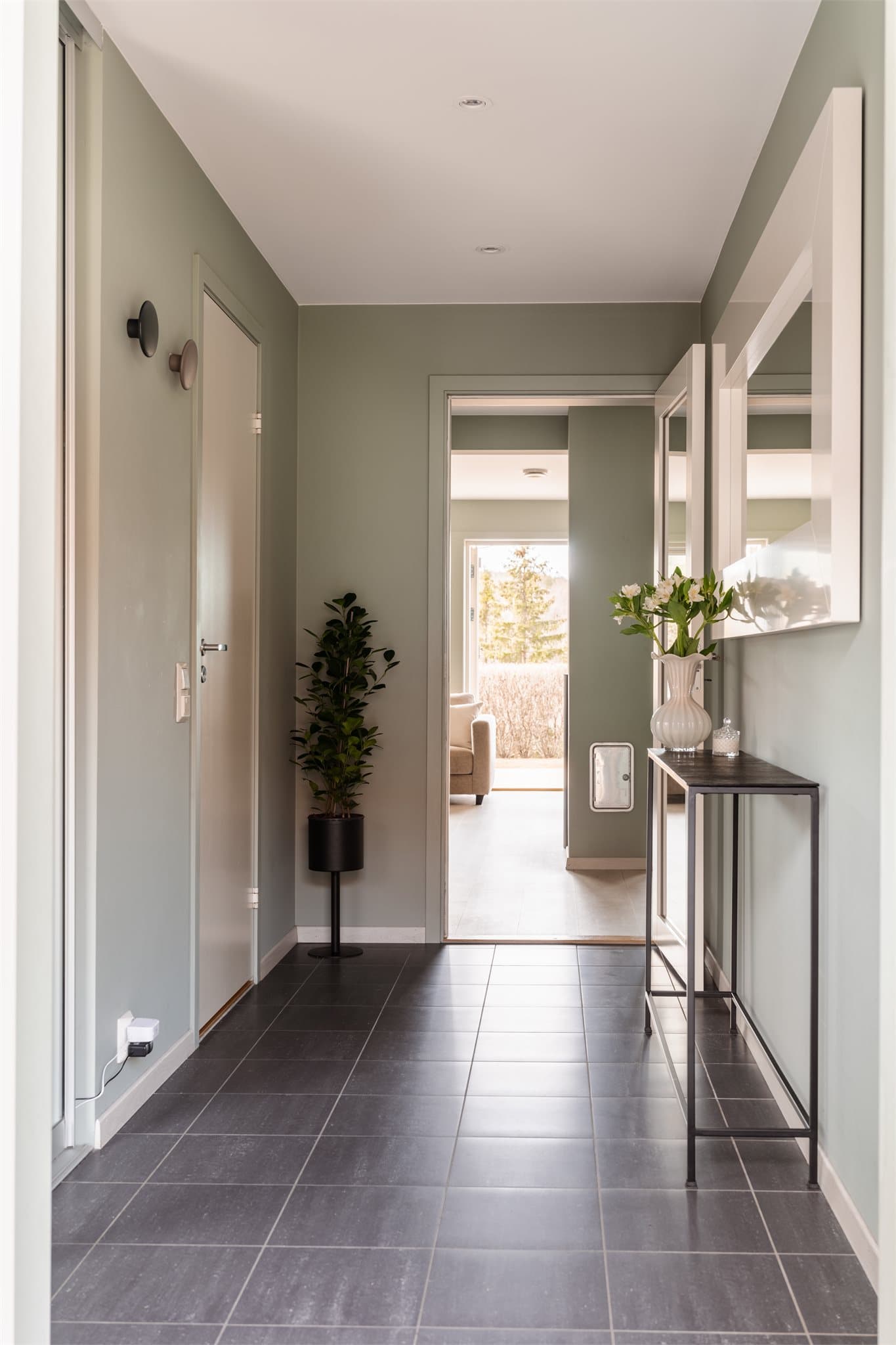 Fra entreen er det inngang til bad med en praktisk innvendig bod, og rommet leder videre inn i boligens sosiale oppholdsrom.