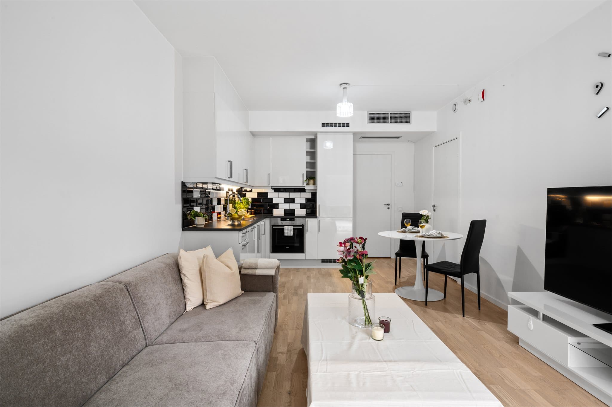 - Den åpne stue- og kjøkkenløsningen måler 20,8 m² og har god plass til sofa og spisebord i hver sin sone -