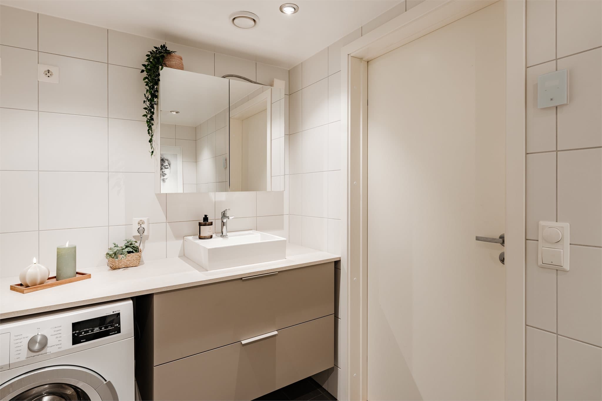 Lekkert flislagt bad med opplegg for vaskemaskin.
