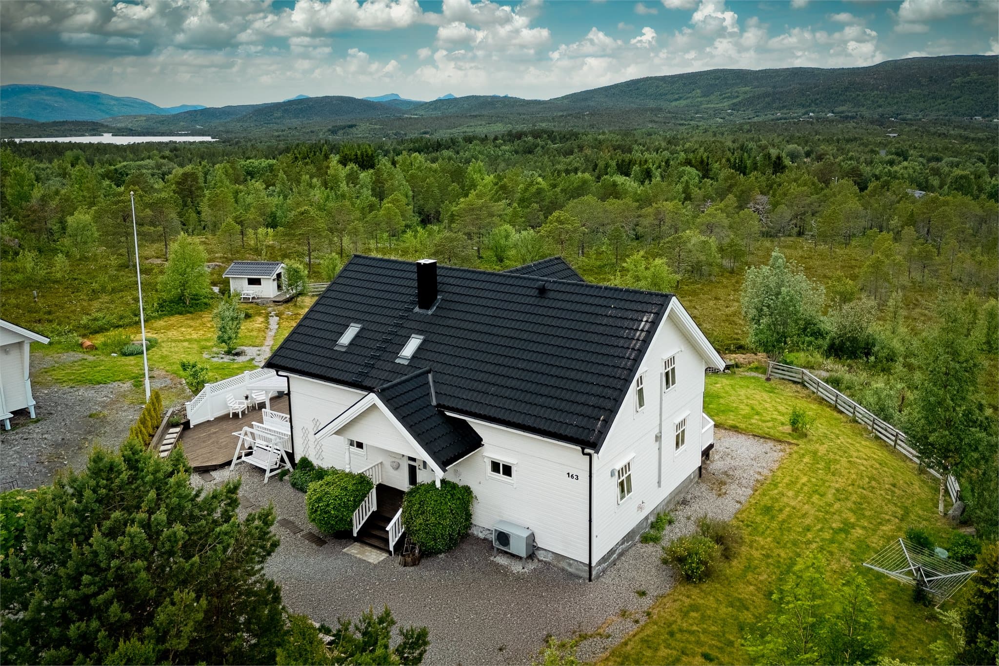 Eiendommen ligger på ei stor tomt med plen og beplantning.