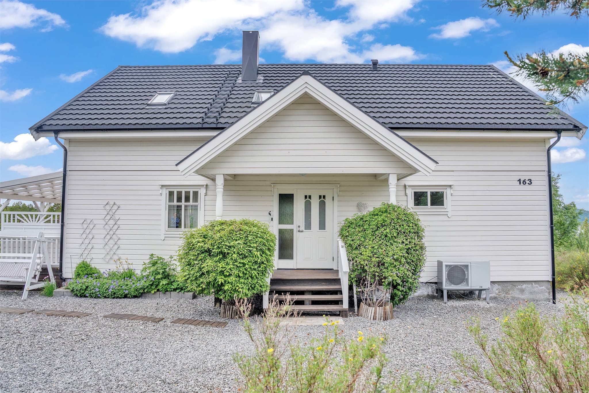 Overbygget inngangsparti med adkomst via utvendig tretrapp.