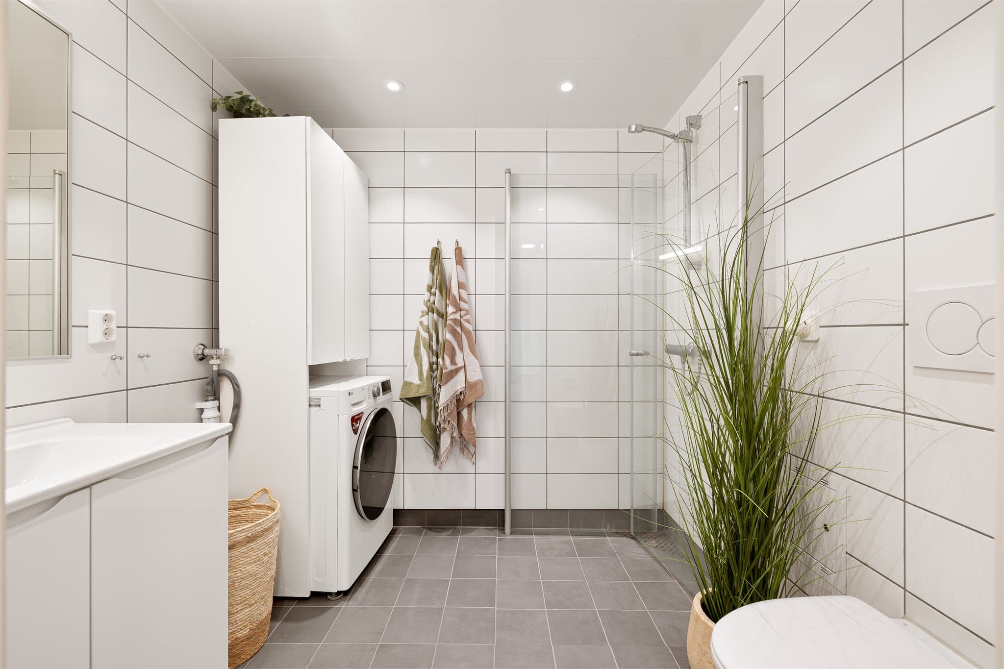 Stilrent, flislagt bad med behagelig gulvvarme og downlights i himlingen.
