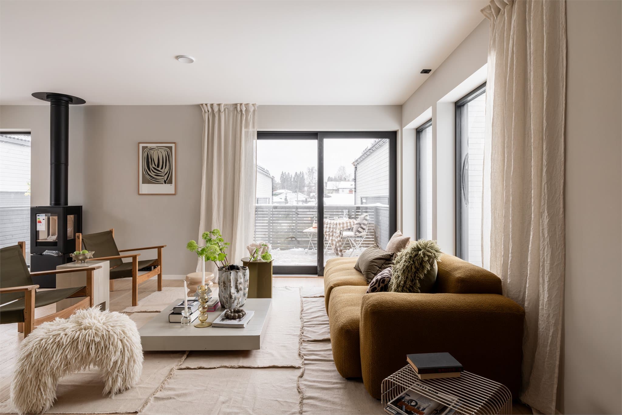 Bilder fra visningsbolig. Stuen i andre etasje er et lunt samlingspunkt med peisovn og gjennomgående parkett.