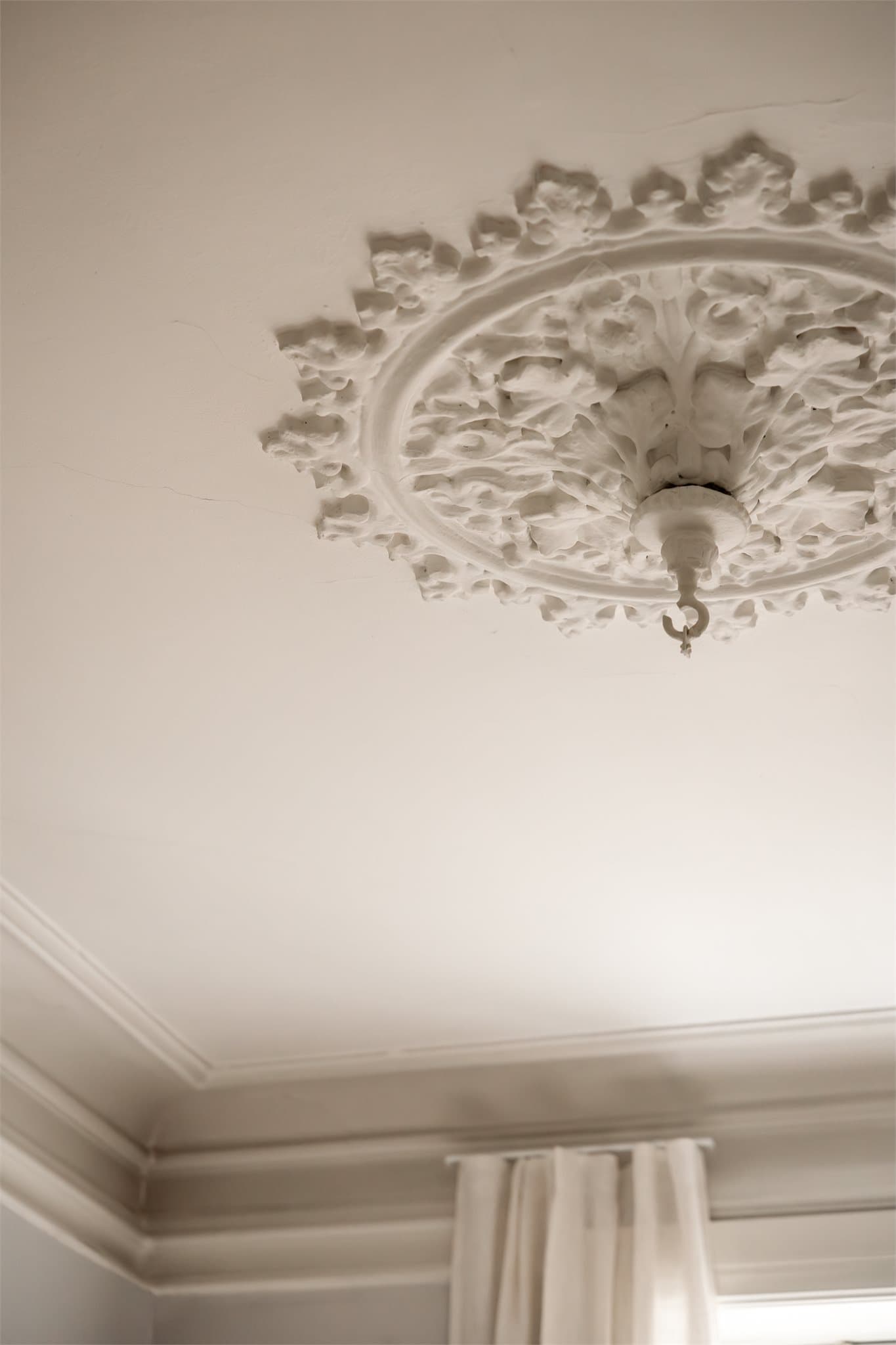 Store vinduer gir rikelig med naturlig lys, mens klassiske detaljer som vakker takrosett og original stukkatur tilfører rommet særpreg og sjarm.