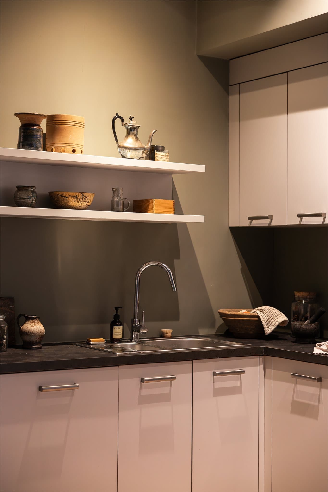 Integrerte hvitevarer som stekeovn, platetopp og oppvaskmaskin, mens kjøl-/fryseskap er plassert i egen matbod.