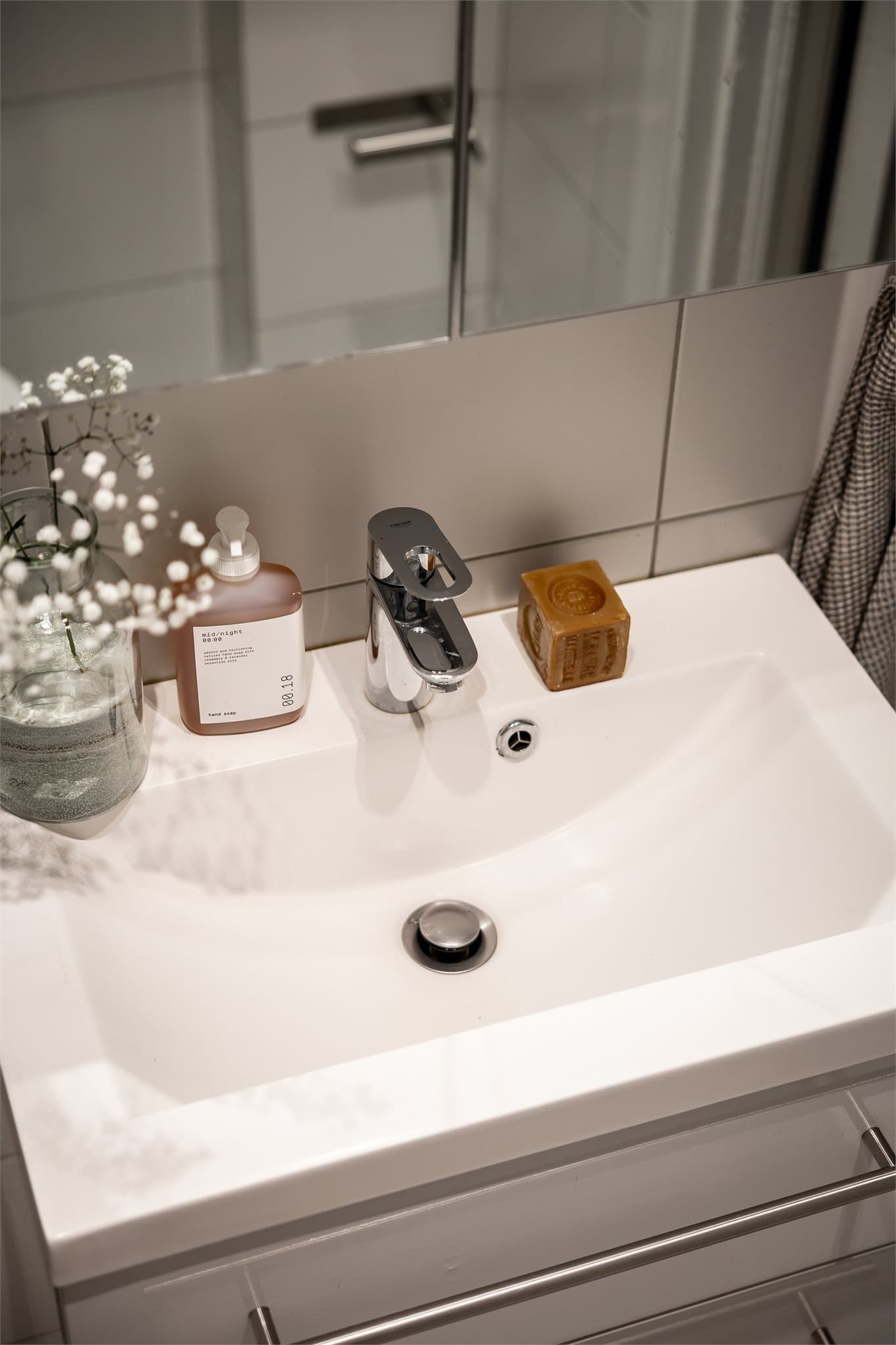 Innredningen består av servant med underskap, gulvstående toalett og dusjløsning med glassvegger i hjørne.