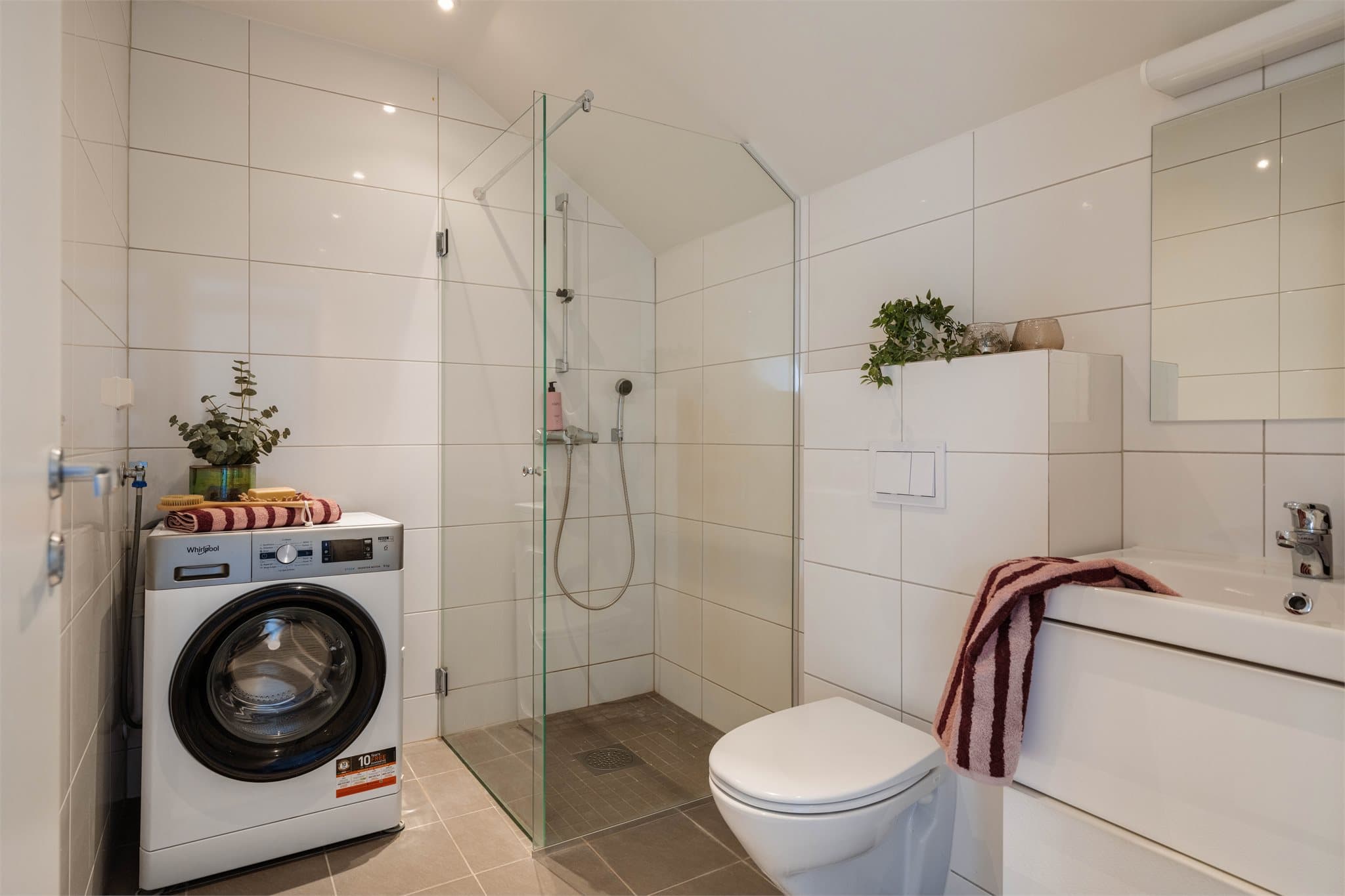 Flislagt bad fra 2014 med varmekabler i gulvet. Dusjen har innfellbare glassdører, og det er opplegg for vaskemaskin.