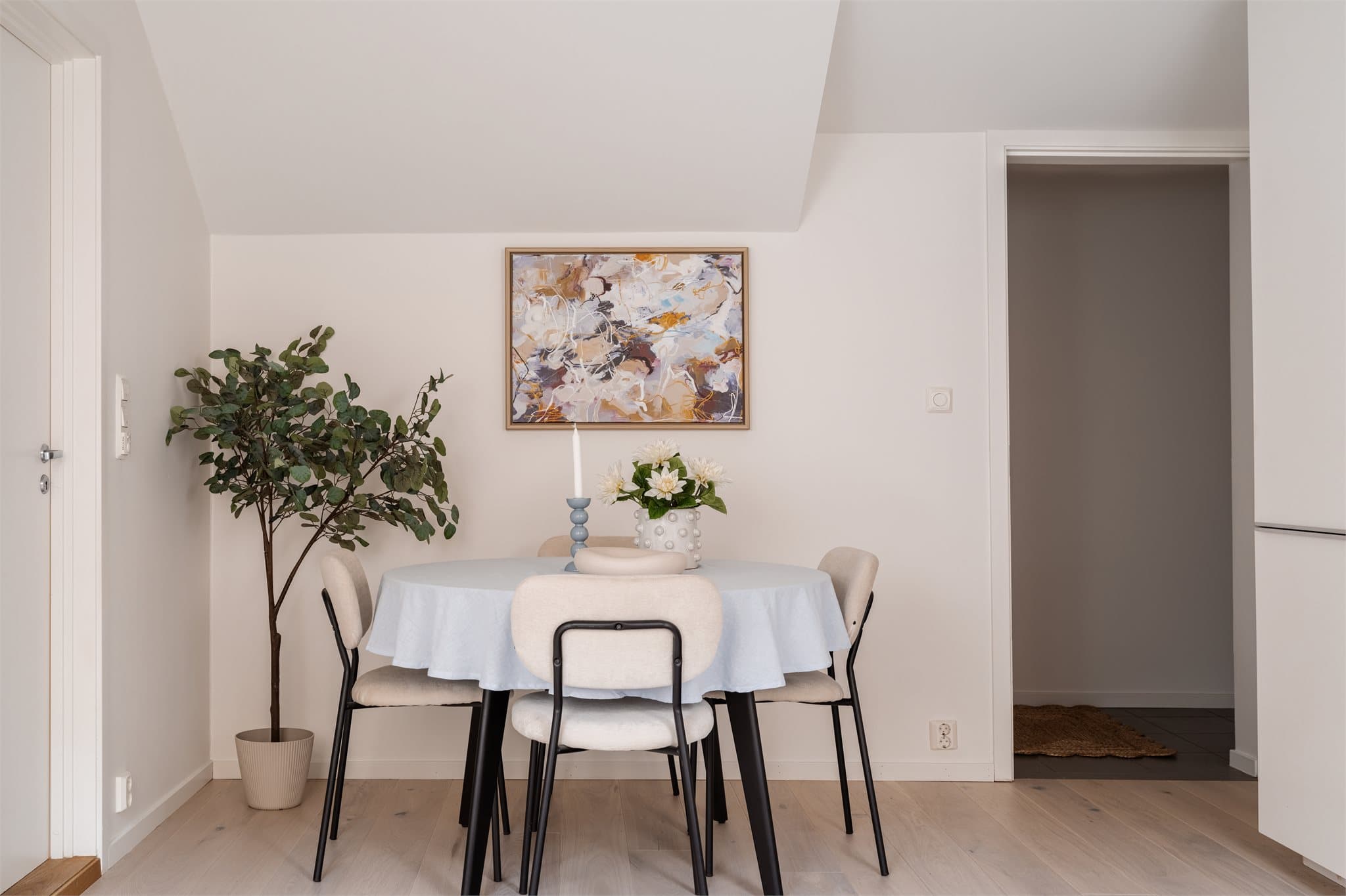 Den åpne løsningen gir en naturlig sone for spiseplass. Gulvet er belagt med en nyere parkett som er gjennomgående i oppholdsrommene.