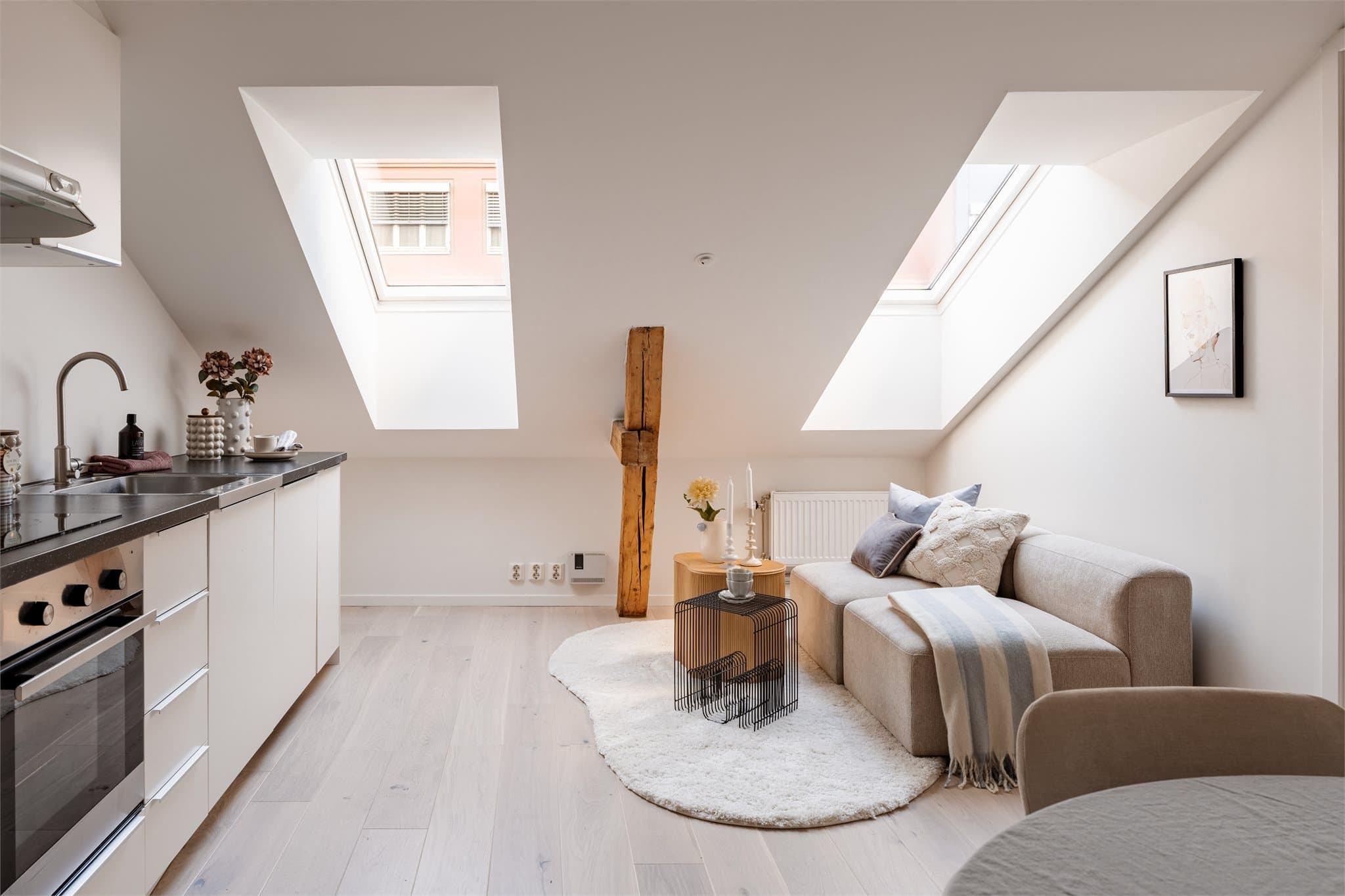 Den åpne stue- og kjøkkenløsningen har en takhøyde på opptil 2,45 meter, og downlights i deler av taket gir behagelig belysning.