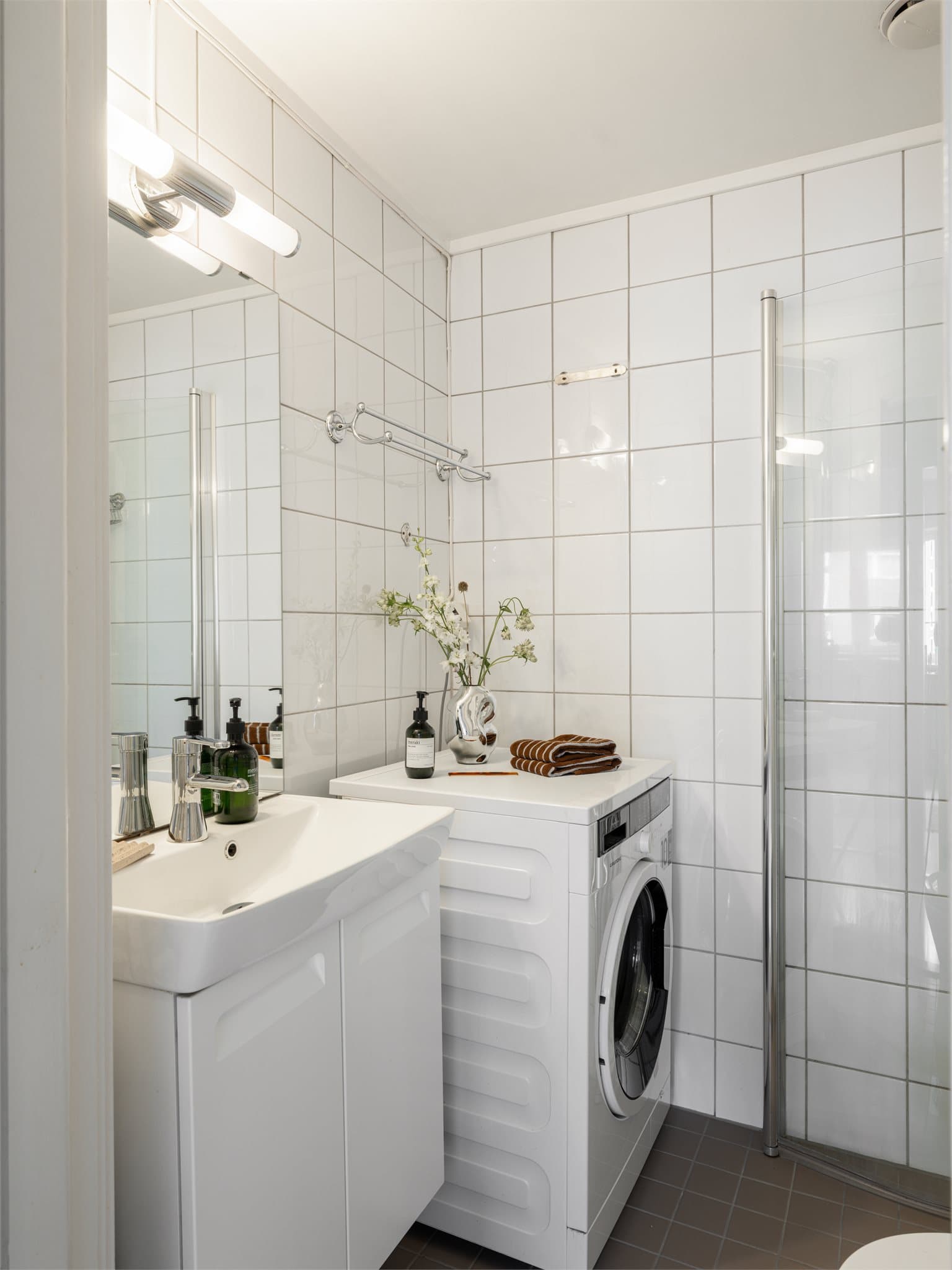 Flislagt bad med varme i gulvet og opplegg for vaskemaskin.