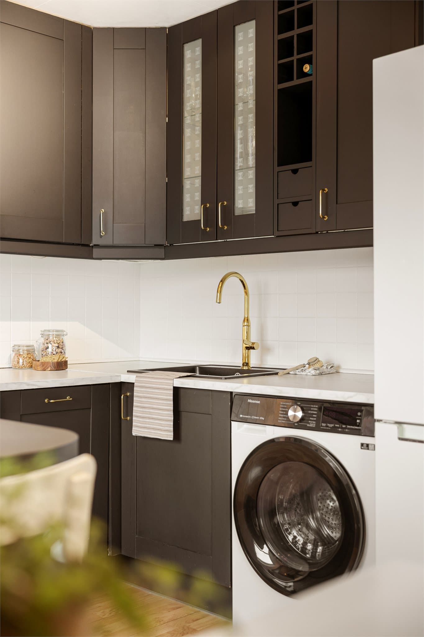 Innredningen har lekre gulldetaljer på håndtak og armatur som gir kjøkkenet et elegant preg.