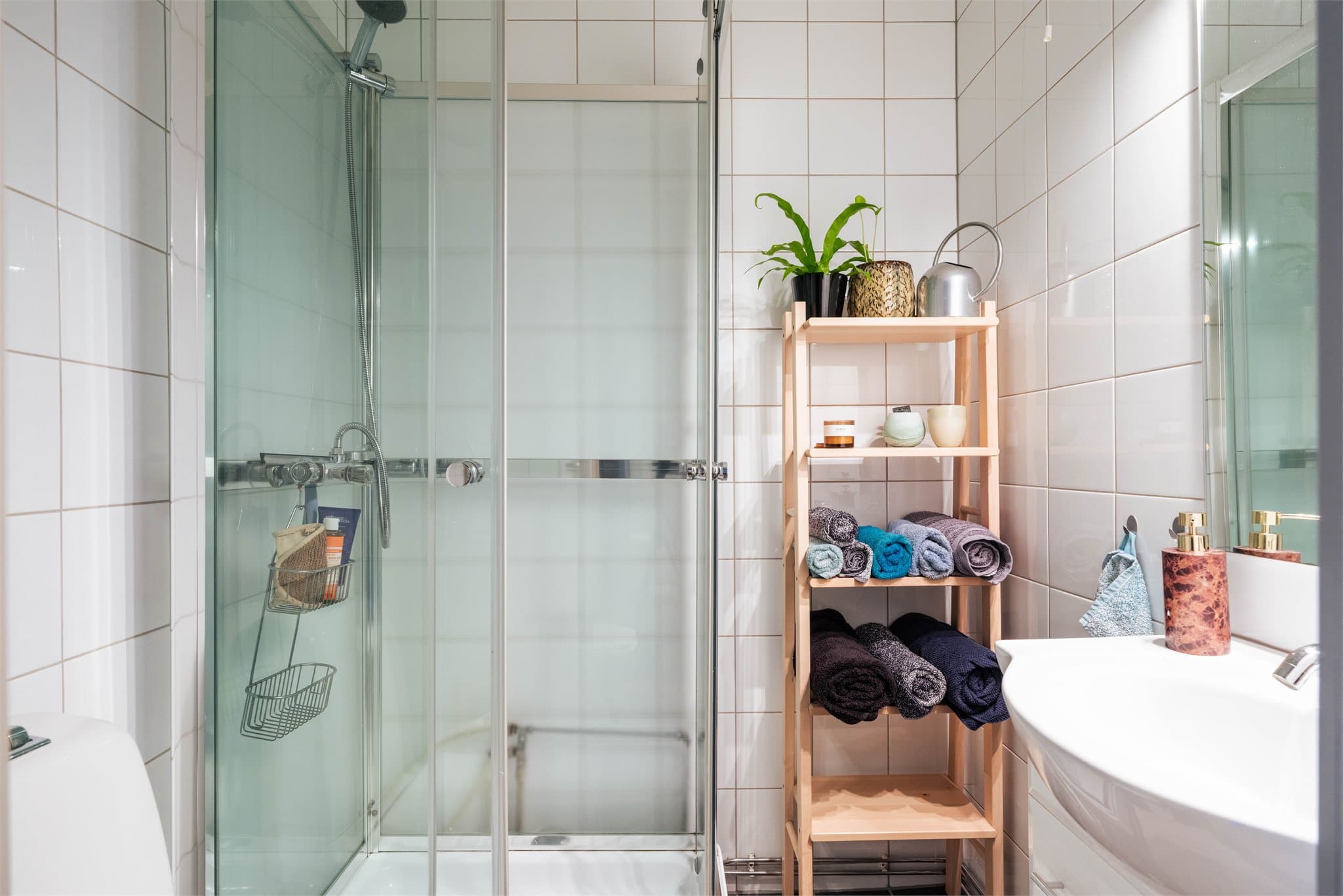 Praktisk og funksjonelt baderom med dusjhjørne, vegghengt toalett og servant. Stilren innredning fra 2012.