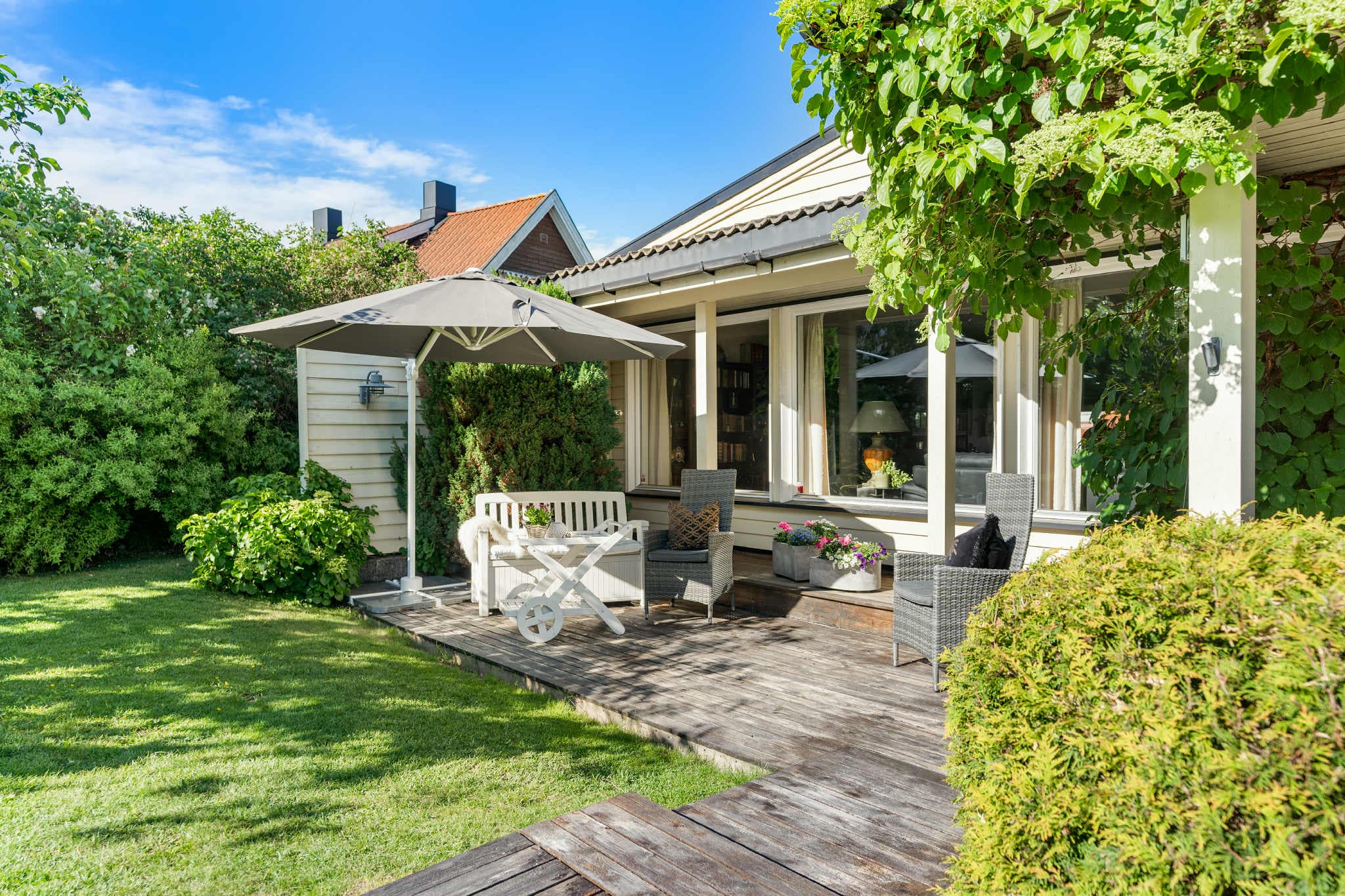 Hagen og terrassen kombinerer solrike områder, skjermet privatliv og frodig beplantning, ideelt for både avslapning og sosiale aktiviteter.