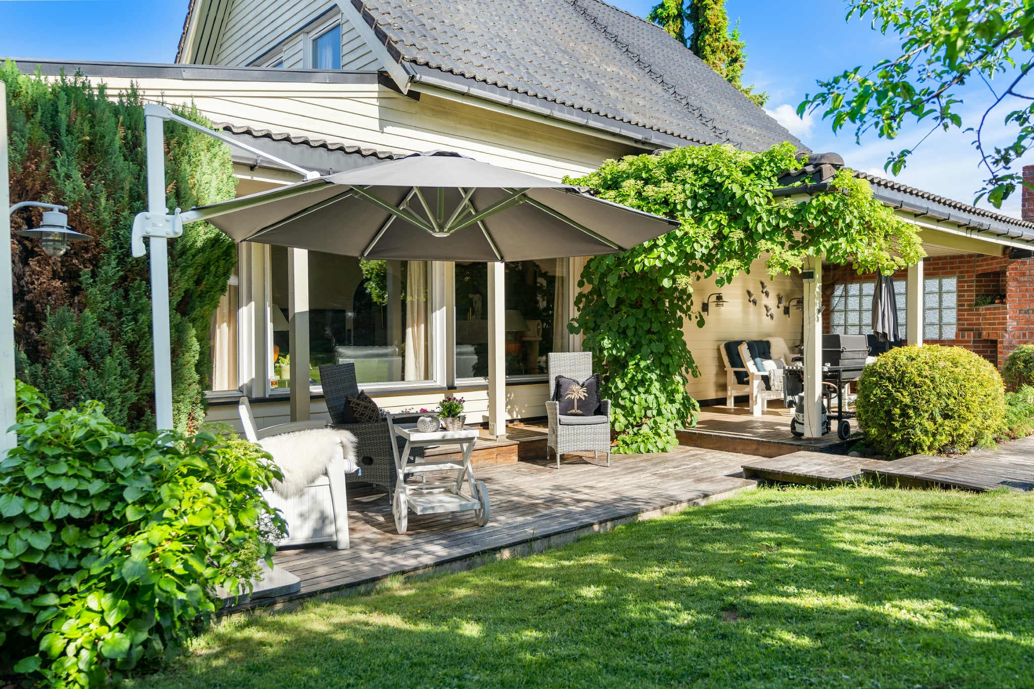 Romslig terrasse stor nok for spisebord, lounge-møbler og grill. Et naturlig samlingspunkt for familie og venner.