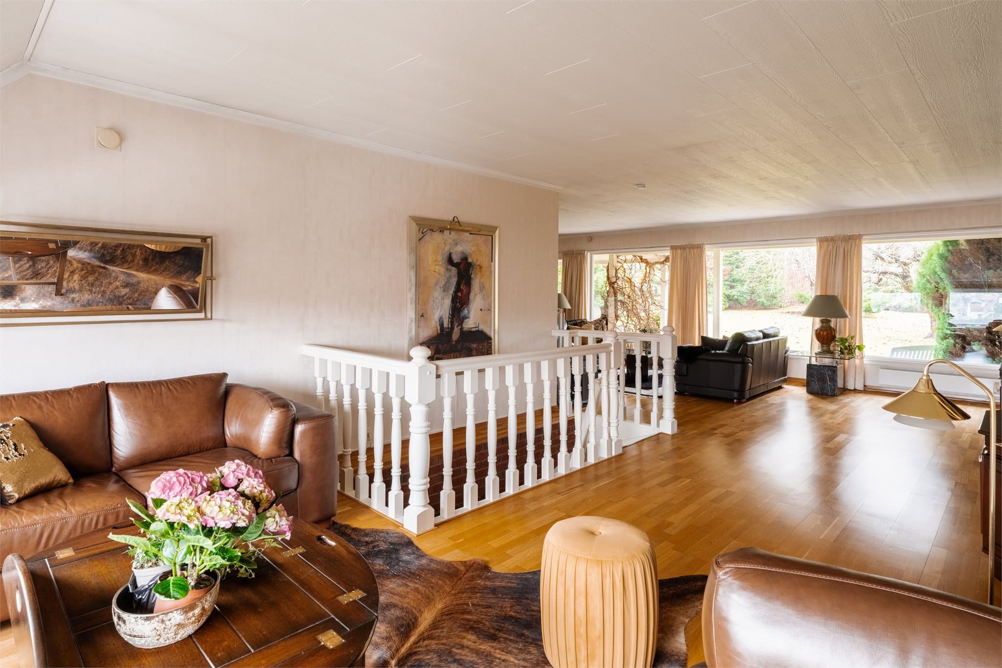 Stuen er lys og romslig, med eikeparkett på gulvet og god plass til flere sittegrupper.