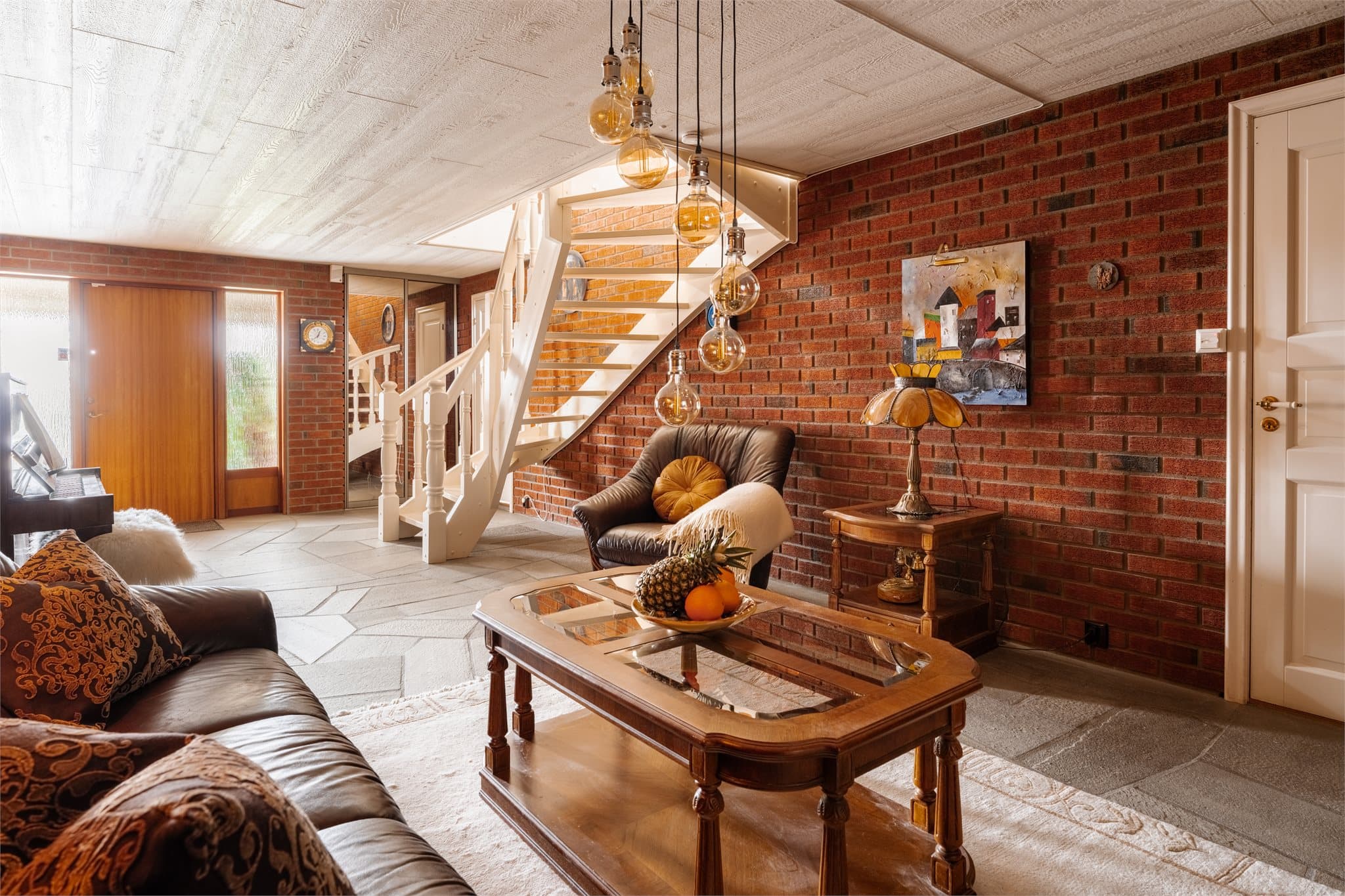 Gulvet har skiferheller med gulvvarme, og en hvitmalt trapp binder etasjen sammen med hovedplanet.