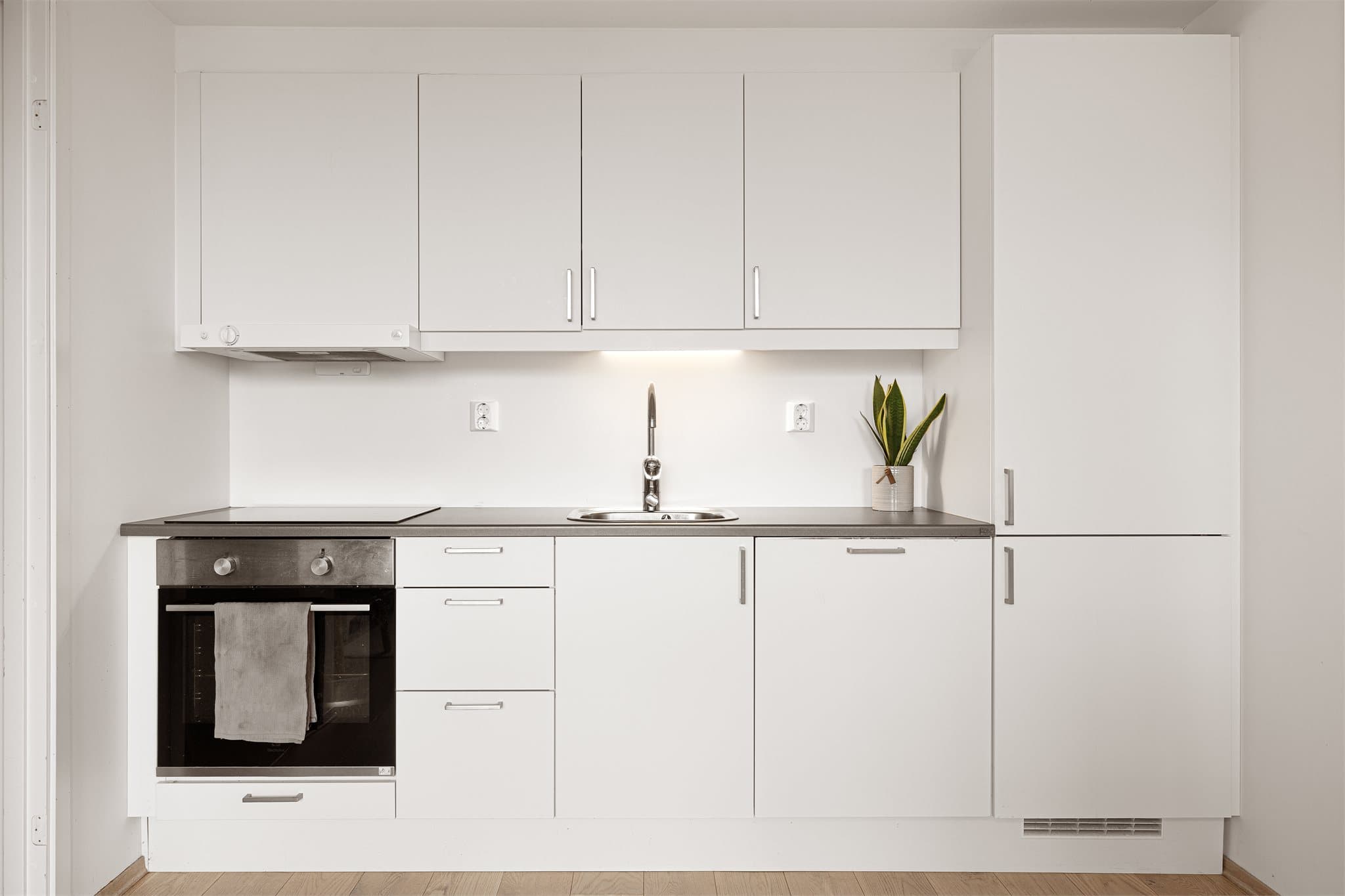 Kjøkkeninnredningen er fra Sigdal med glatte fronter og benkeplate av laminat.