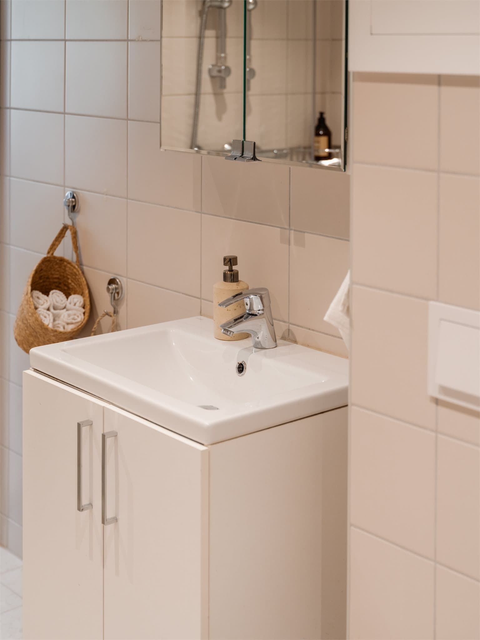 Stilrent baderom med elegant servantinnredning og gode oppbevaringsmuligheter i skap.