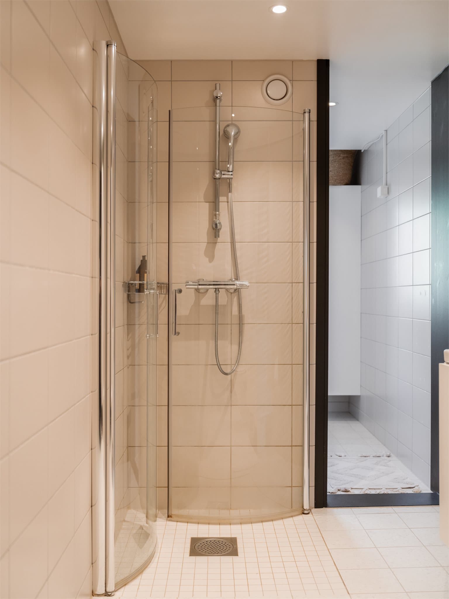 Dusjen er plassert på gulv bak innfellbare dører i herdet glass.