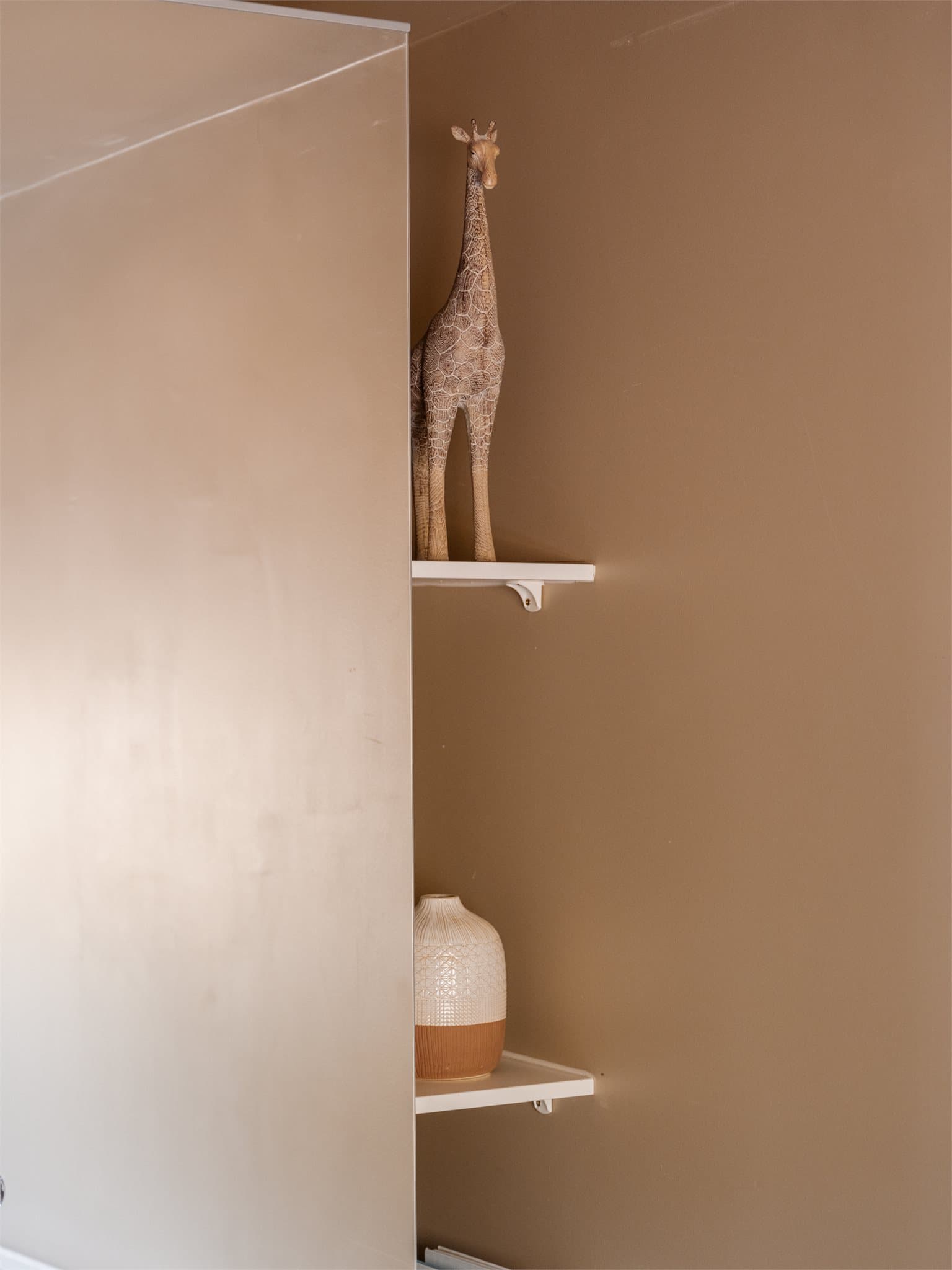 Rommet er malt i en lys og behagelig beigetone, som gir rommet en lun og innbydende følelse.