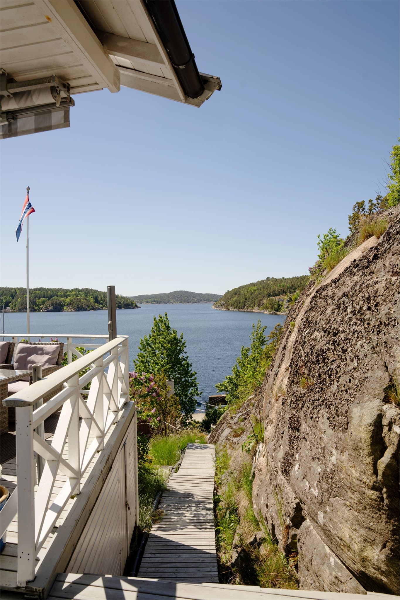 En tretrapp leder ned fra hytta. Deler av trappen er felles med nabo.