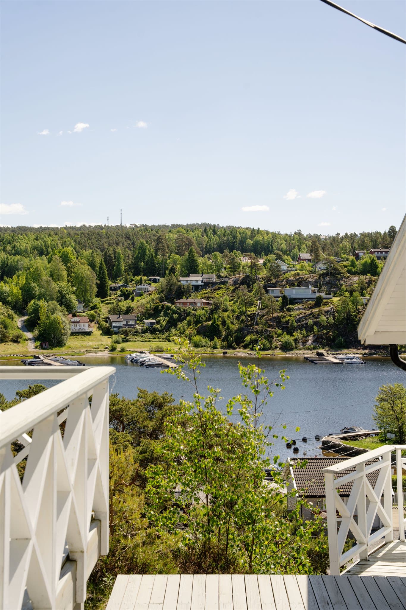 Fra eiendommen ser man ned mot småbåthavnen og stranden.