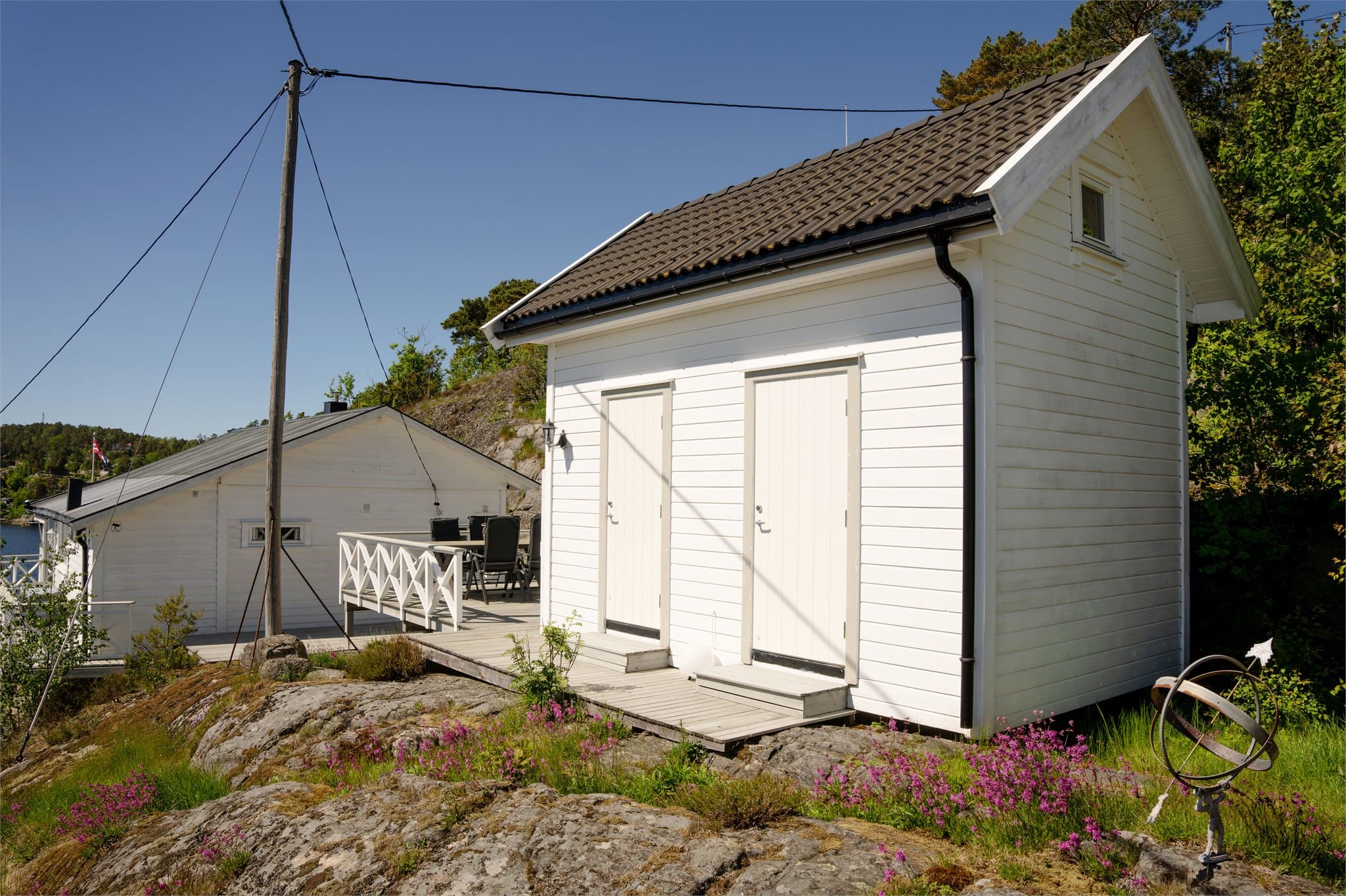 Annekset fra 2020 er kledd med liggende trepanel og har saltak tekket med betongtakstein.