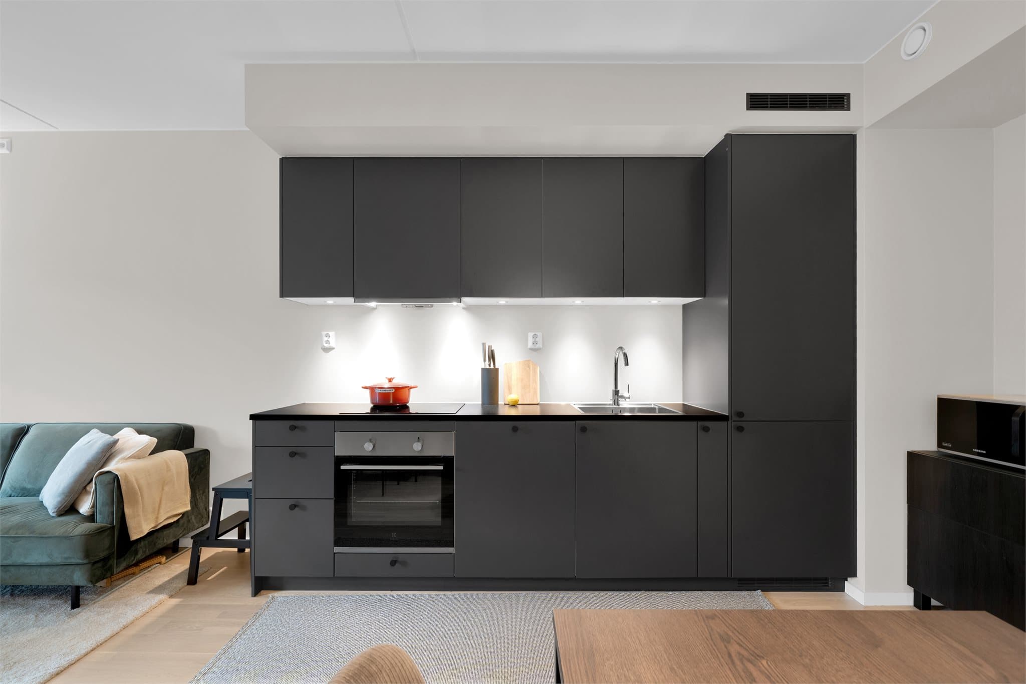 Kjøkkenet har stilren innredning med glatte fronter og laminat benkeplate.