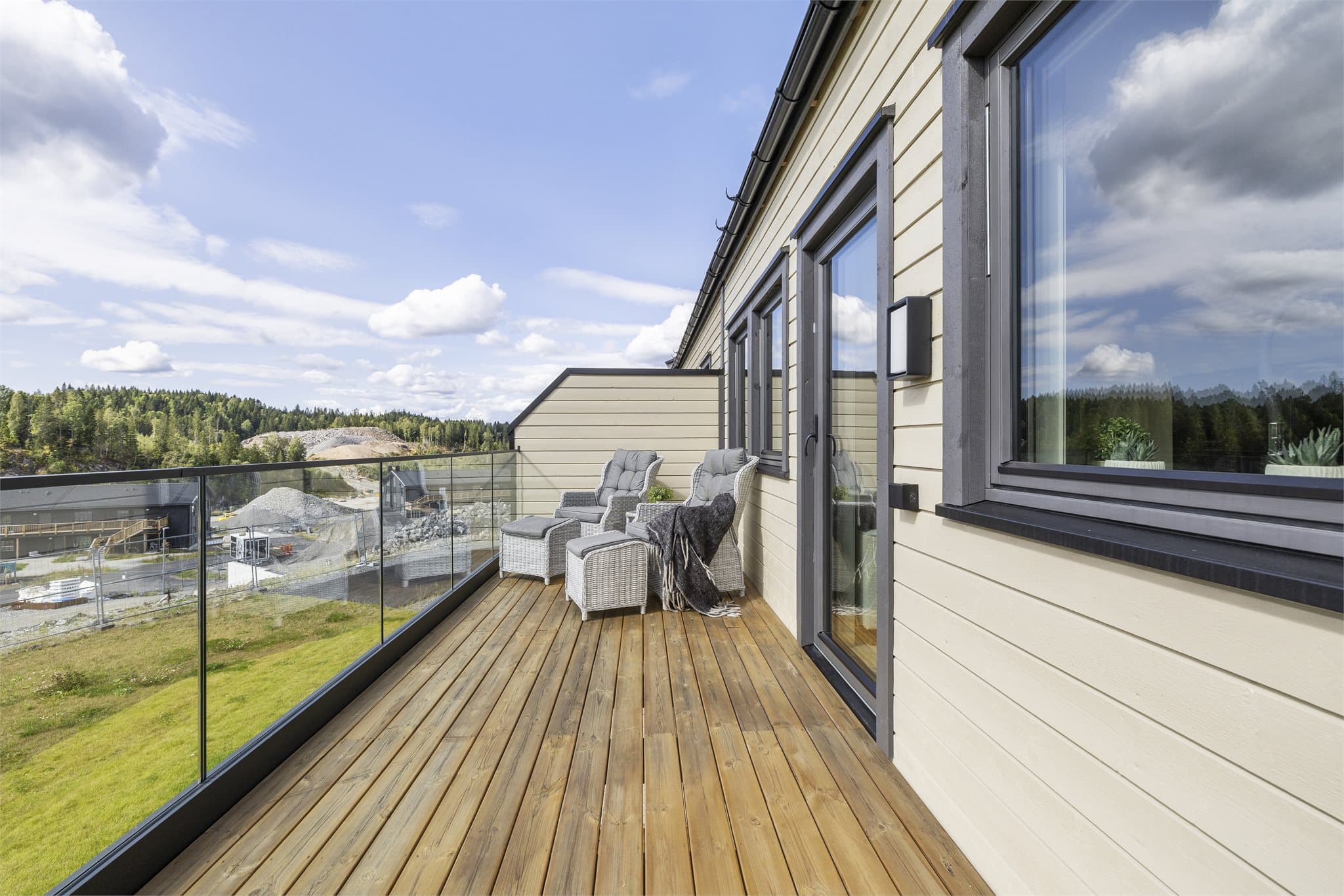 Tregulv og rekkverk i stål/aluminium med innfelt glass gir uteplassen et moderne uttrykk.