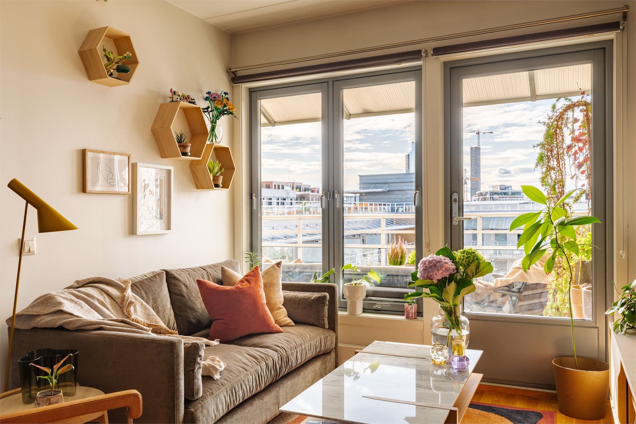 Sofaen får en naturlig plassering ved vinduene, og herfra er det direkte utgang til en solrik uteplass.