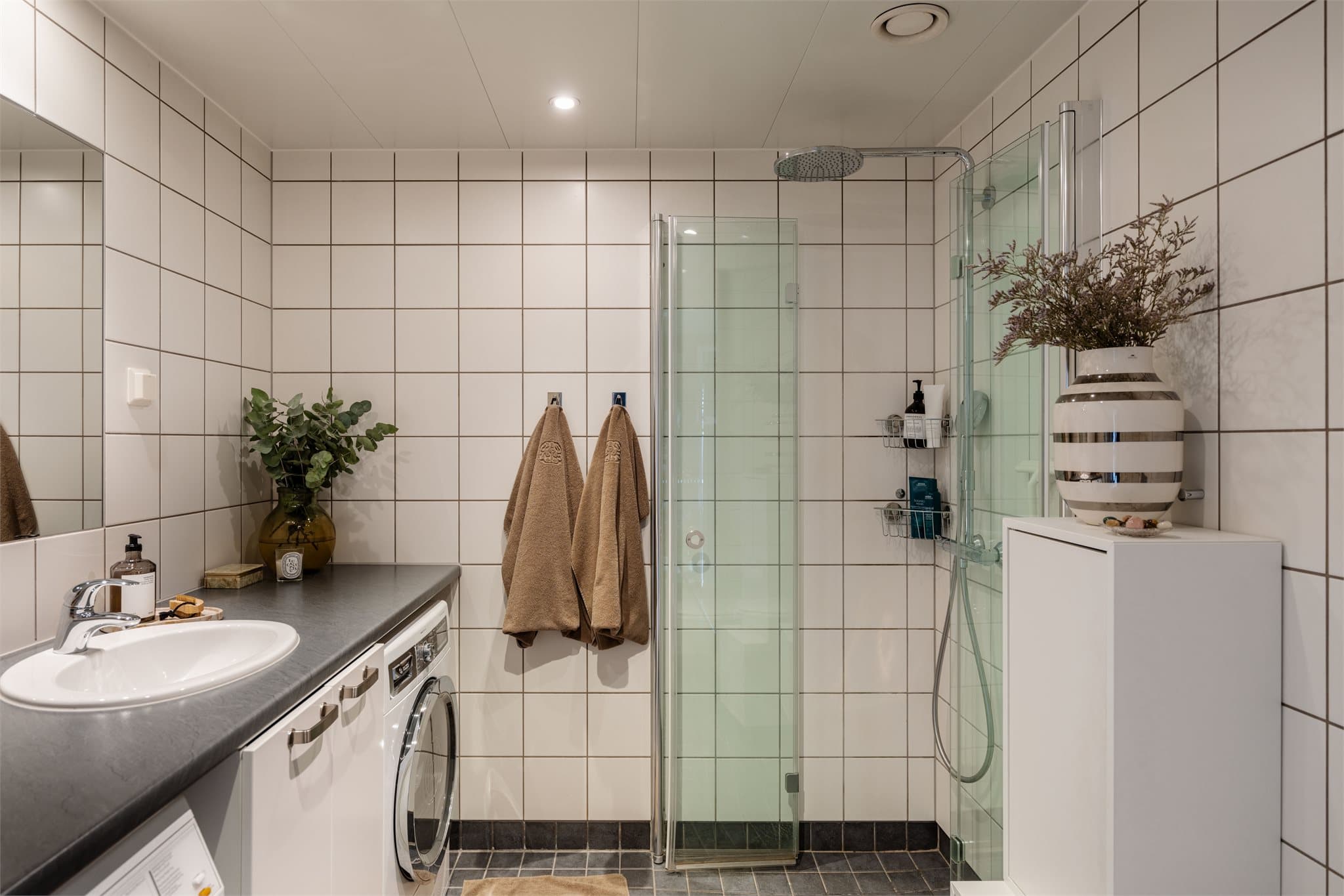 Badet har flislagte gulv og vegger, himlingsplater av stål i tak og elektriske varmekabler.