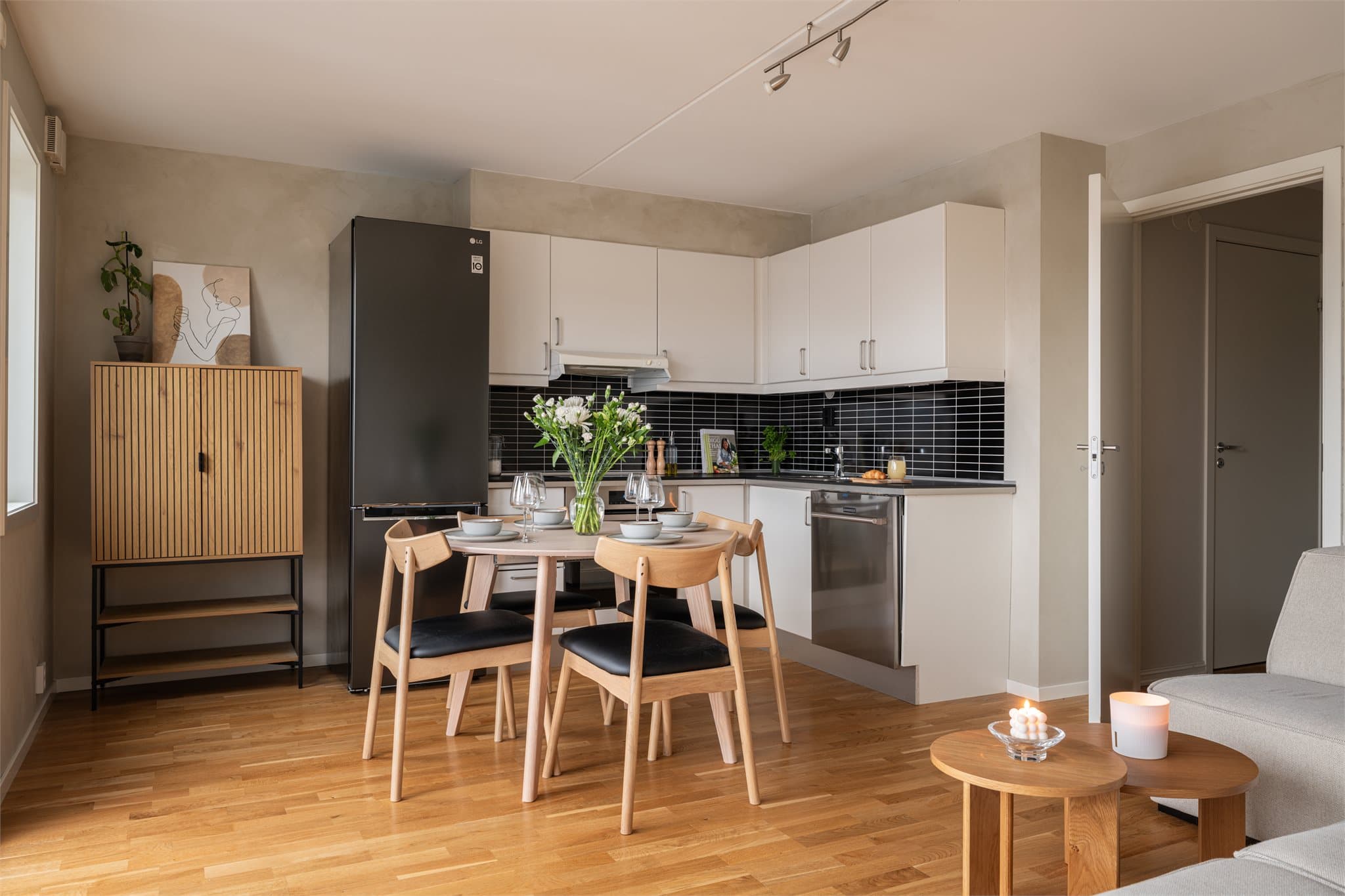 Kjøkkeninnredningen fra Sigdal ligger i en L-form, og har en tidløs og lys innredning med glatte, fabrikklakkerte fronter og laminat benkeplate.