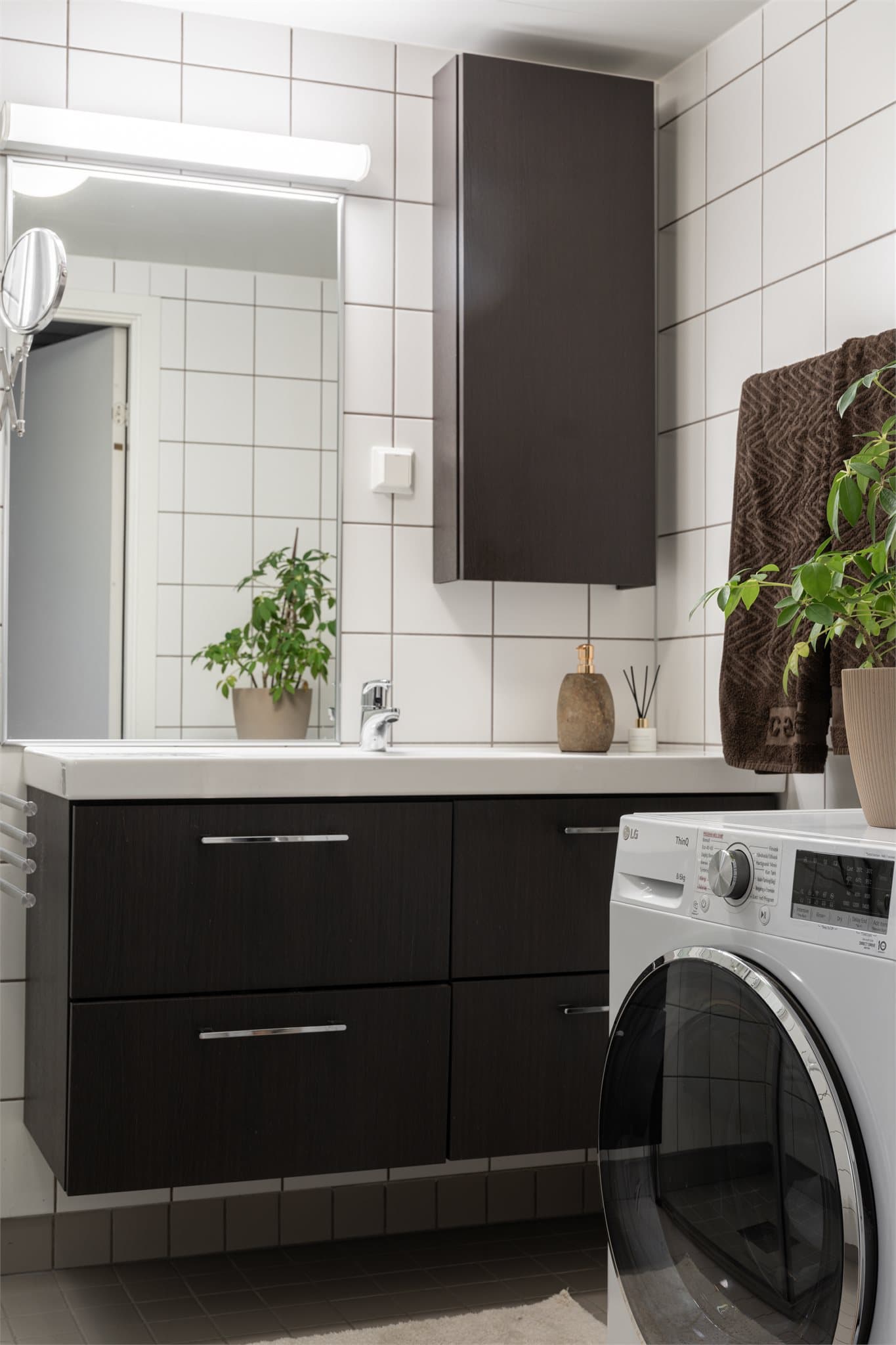 Badet har et romslig og pent vegghengt servantskap med heldekkende servant. Over vasken er det også et vegghengt speil.