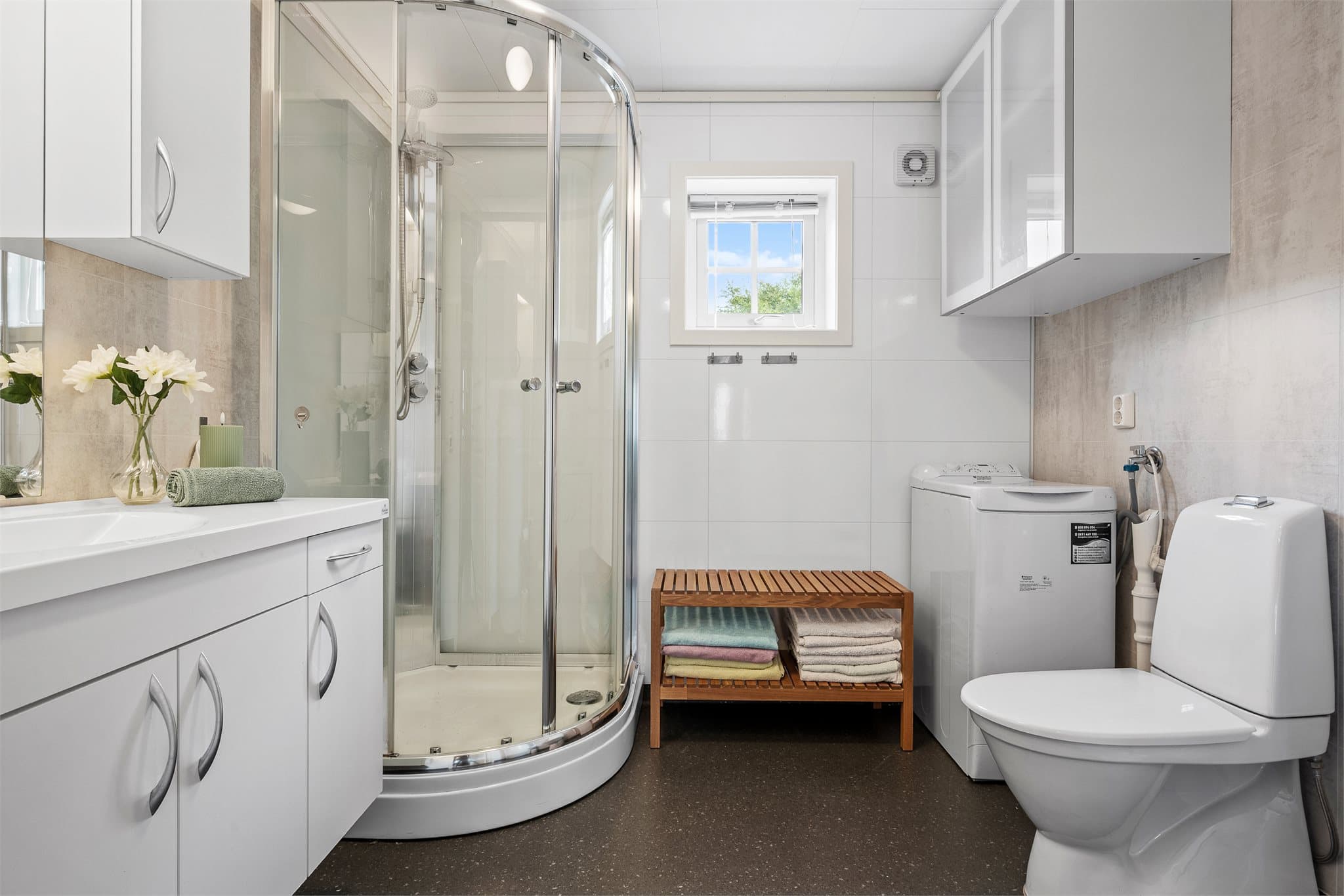 Badet har servantinnredning, toalett og dusjkabinett, samt plass til vaskemaskin og øvrig møblement.