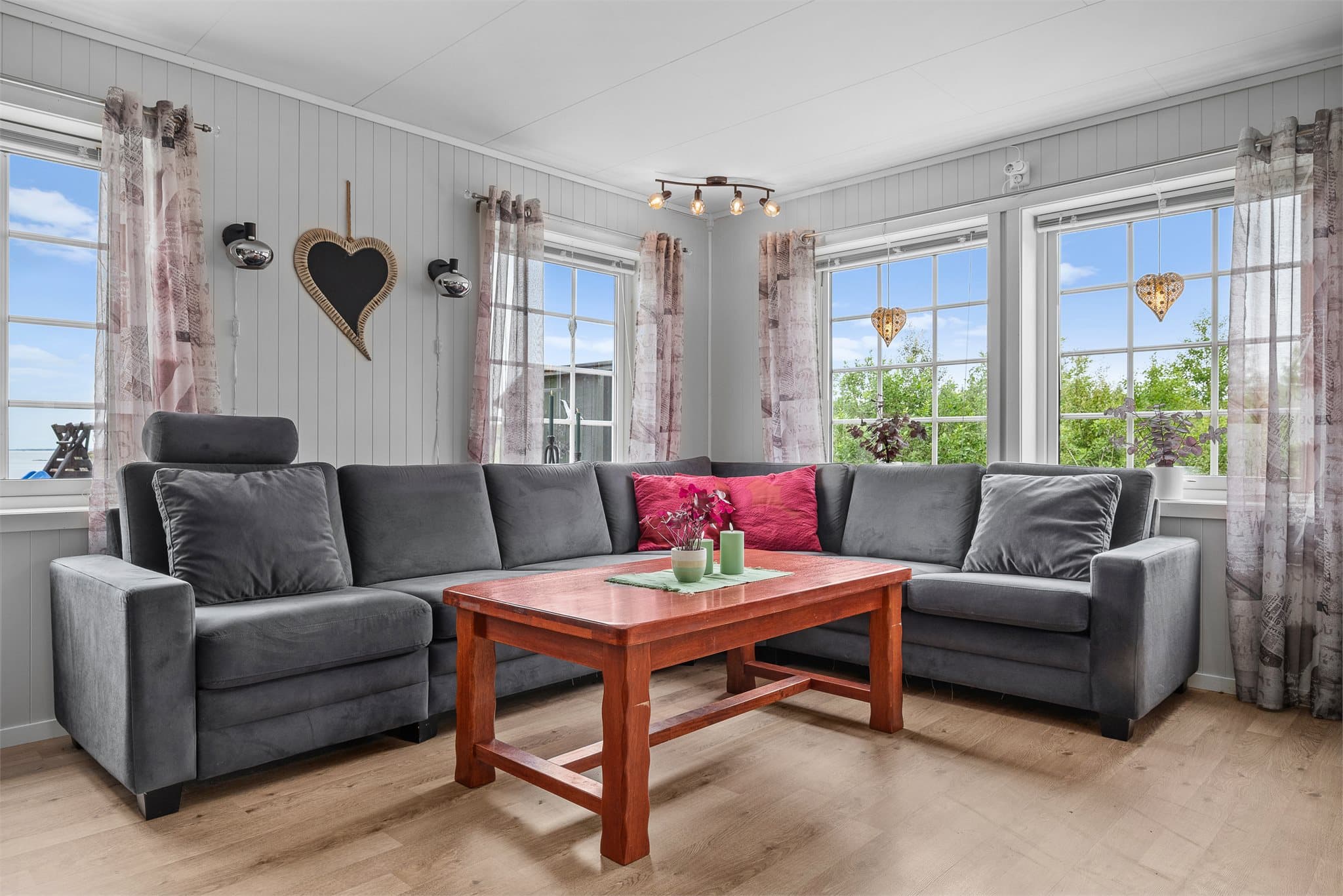 En lys og innbydende stue med store vindusflater som slipper inn rikelig med dagslys.