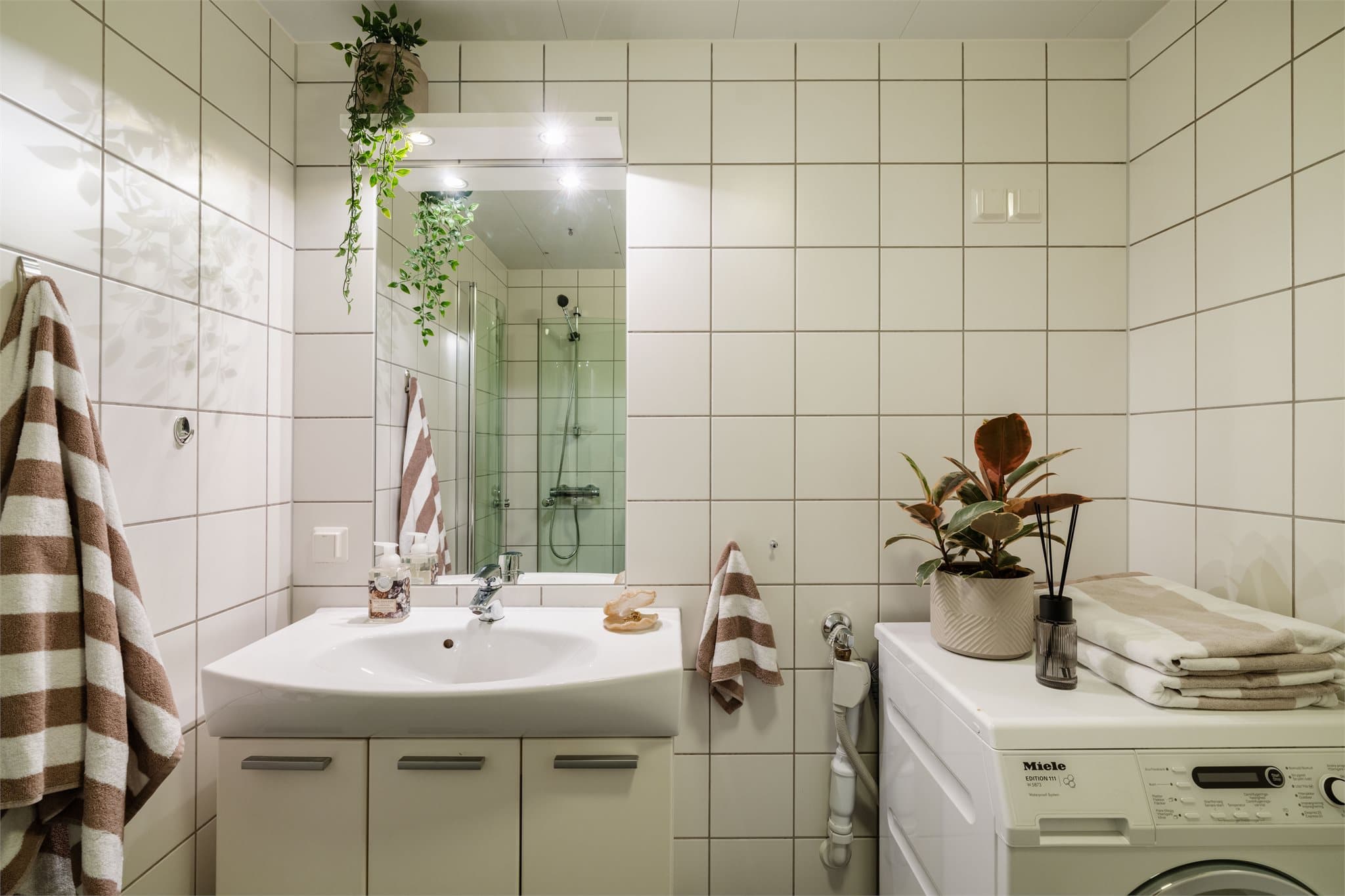 Badet er praktisk innredet med vegghengt toalett og opplegg for vaskemaskin.