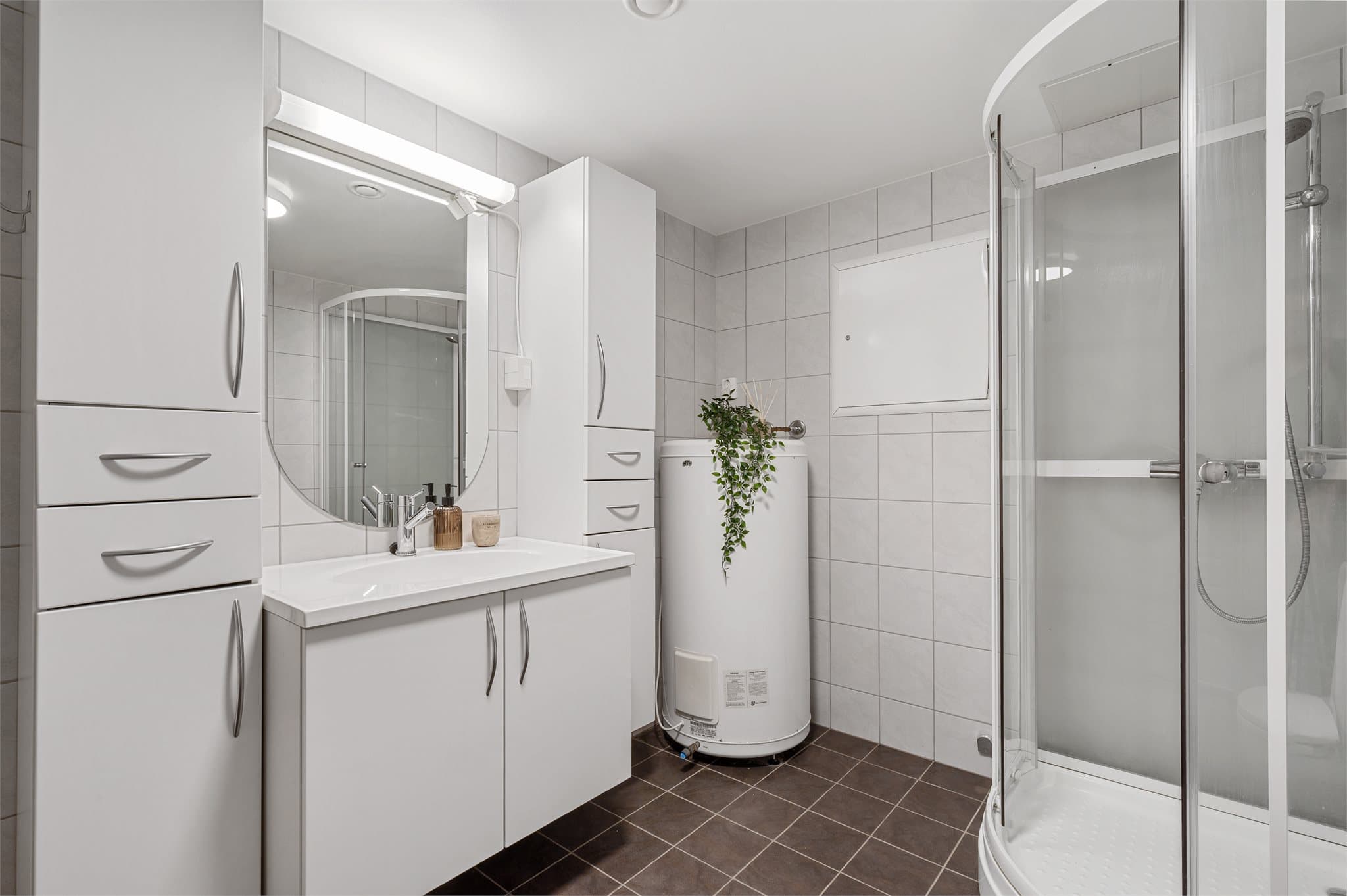 - Badet inneholder gulvmontert toalett, benkeskap med servant og dusjkabinett -