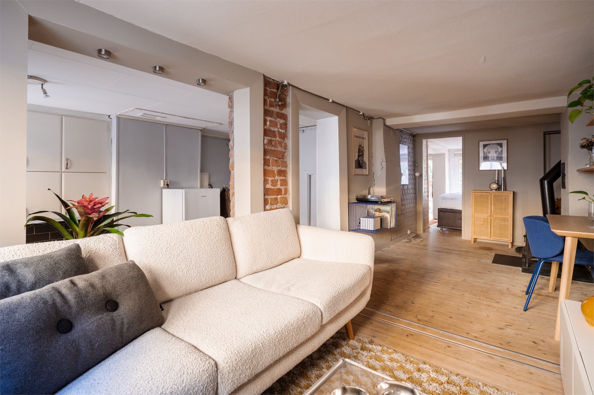 Gulvet er i heltre, som gir en varm og eksklusiv følelse. Mellom stue og kjøkken finner du en stilfull teglesteinsvegg som tilfører leiligheten karakter og et moderne særpreg.