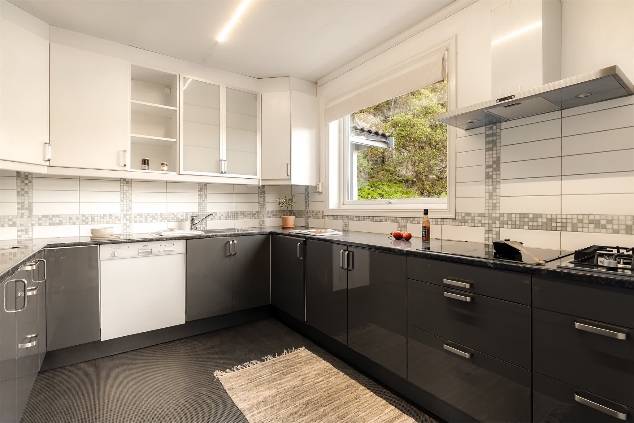 - Kjøkkeninnredning fra IKEA med glatte fronter/vitrineskap og benkeplate i laminat med nedfelt stålvask med avrenningsbrett og ett-greps blandebatteri -