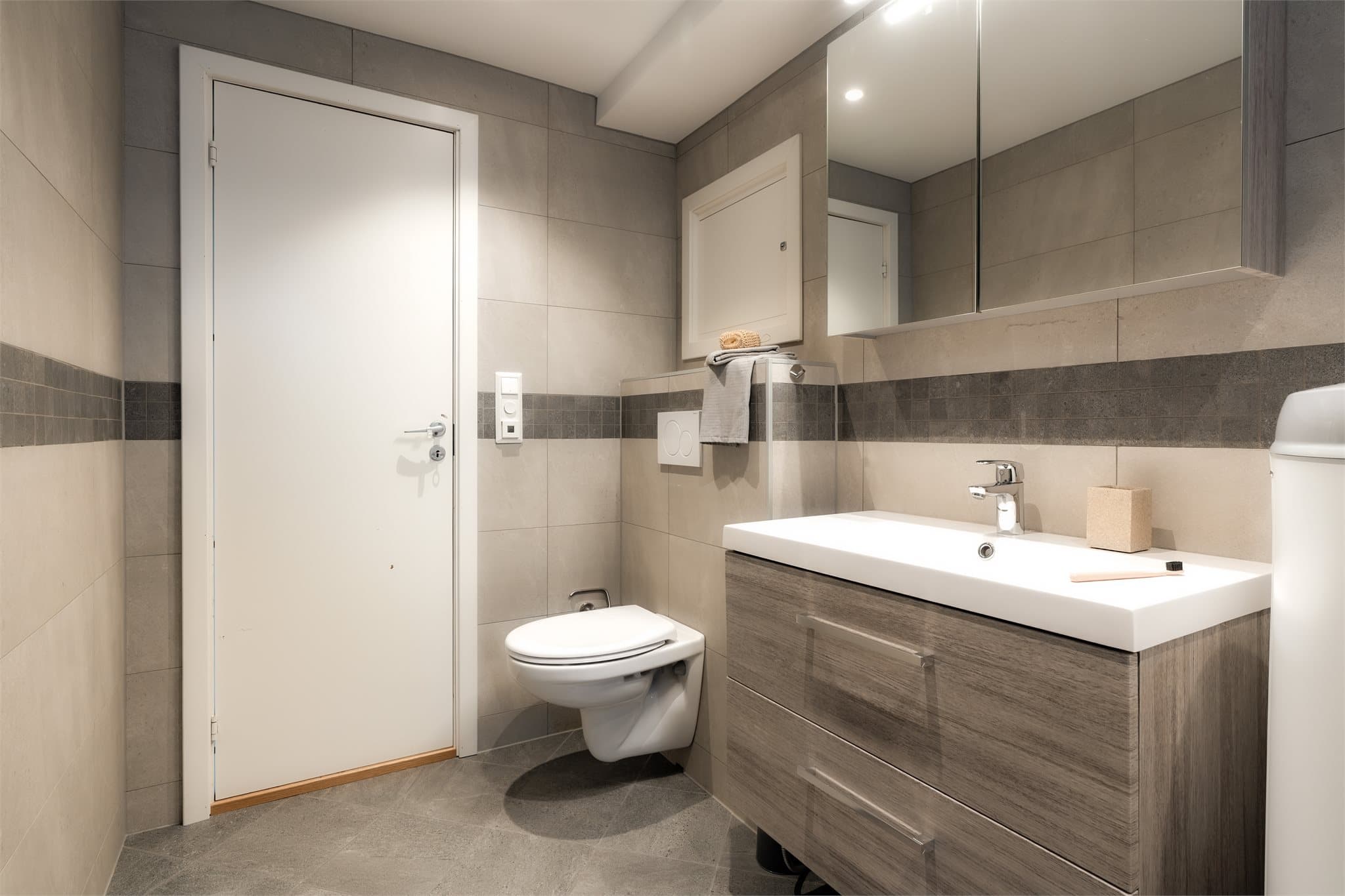 - Badet er innredet med heldekkende servant, baderomsmøbel med laminerte fronter, speilskap med belysning, toalett, fordelerskap til rør-i-rør, opplegg for vaskemaskin og dusj -