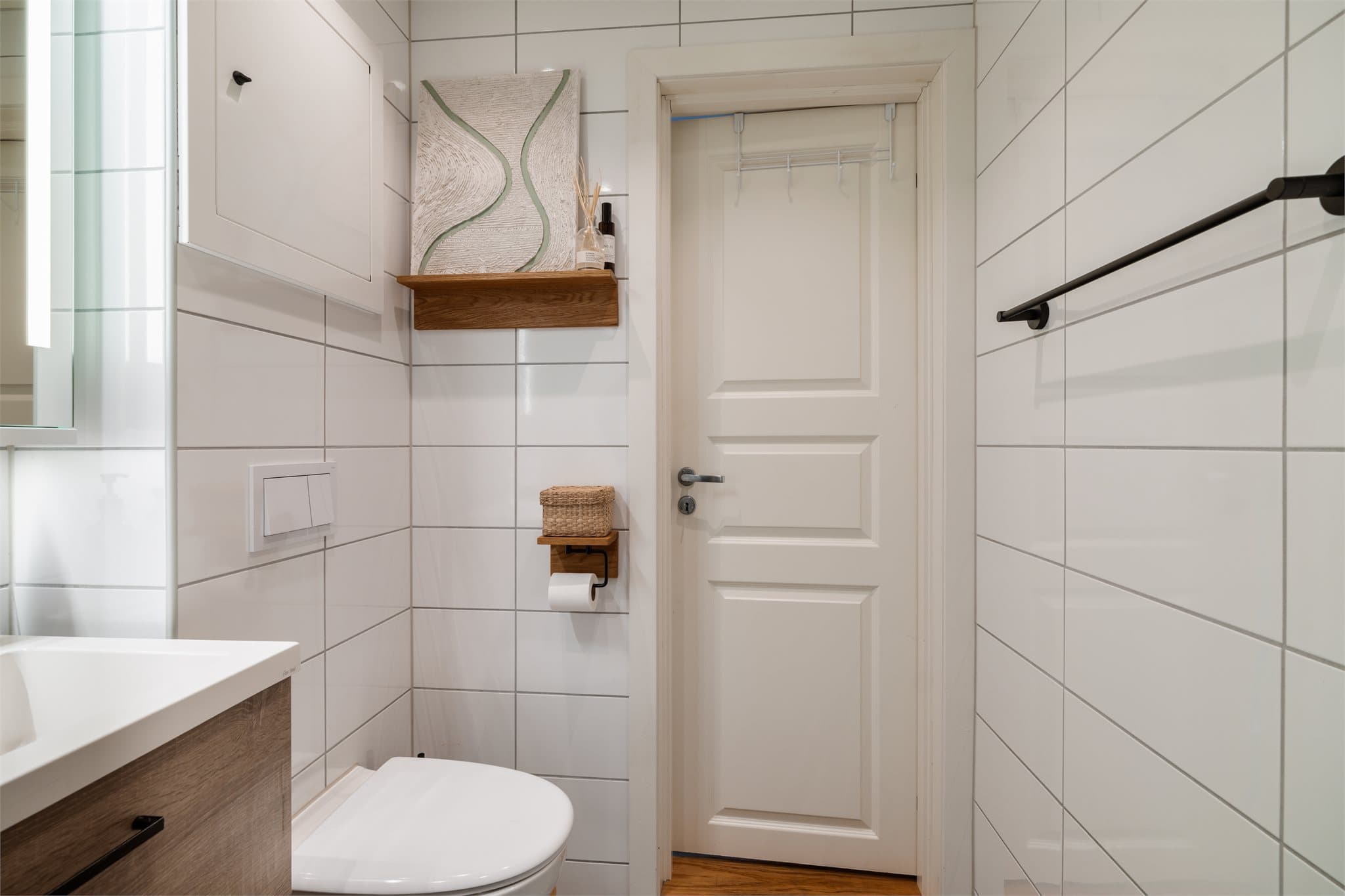 Badet har flislagte vegger og downlights i himling, som gir et moderne uttrykk