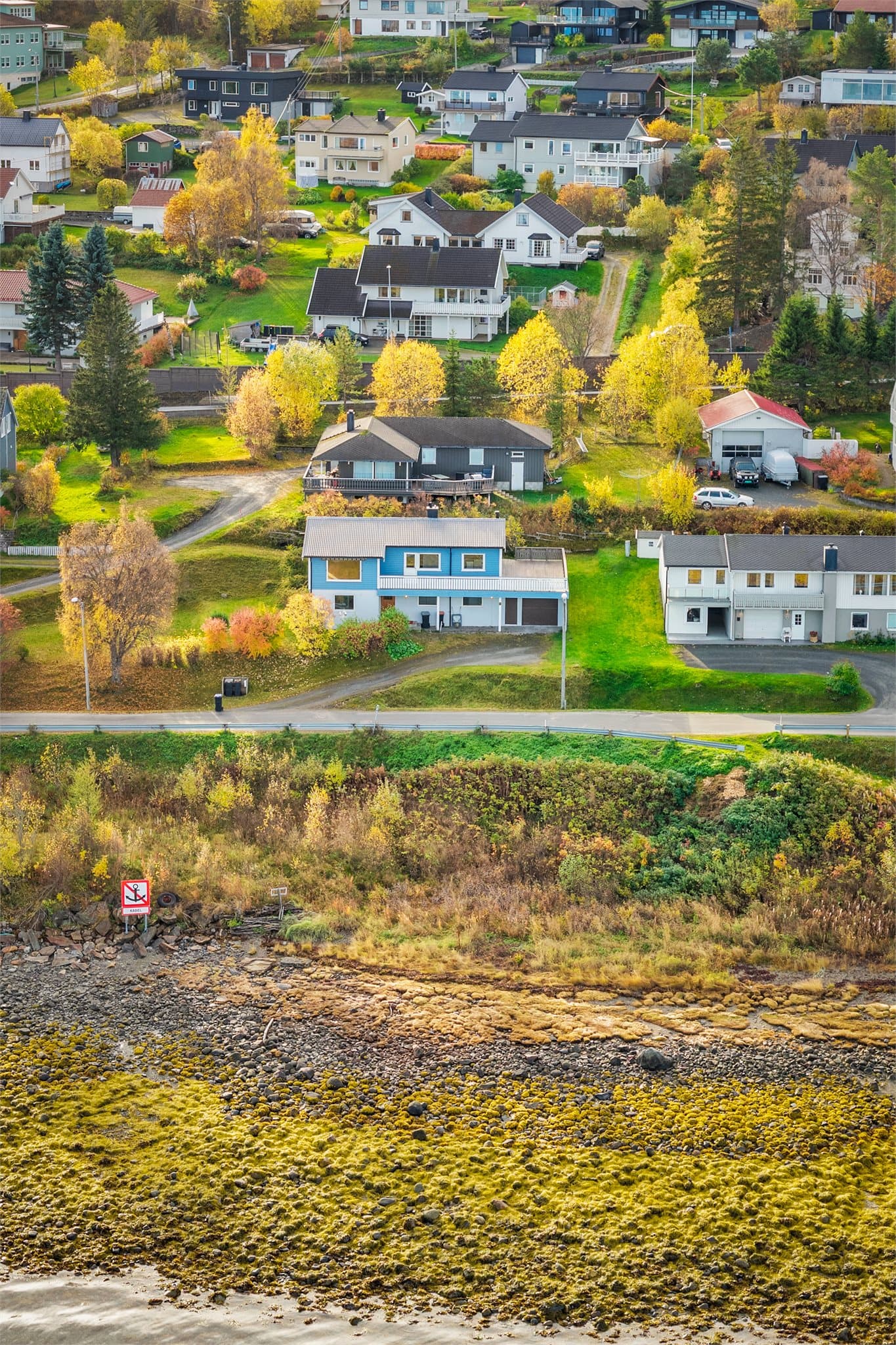 Eiendommen sett fra sjøsiden med direkte nærhet til strandsonen.