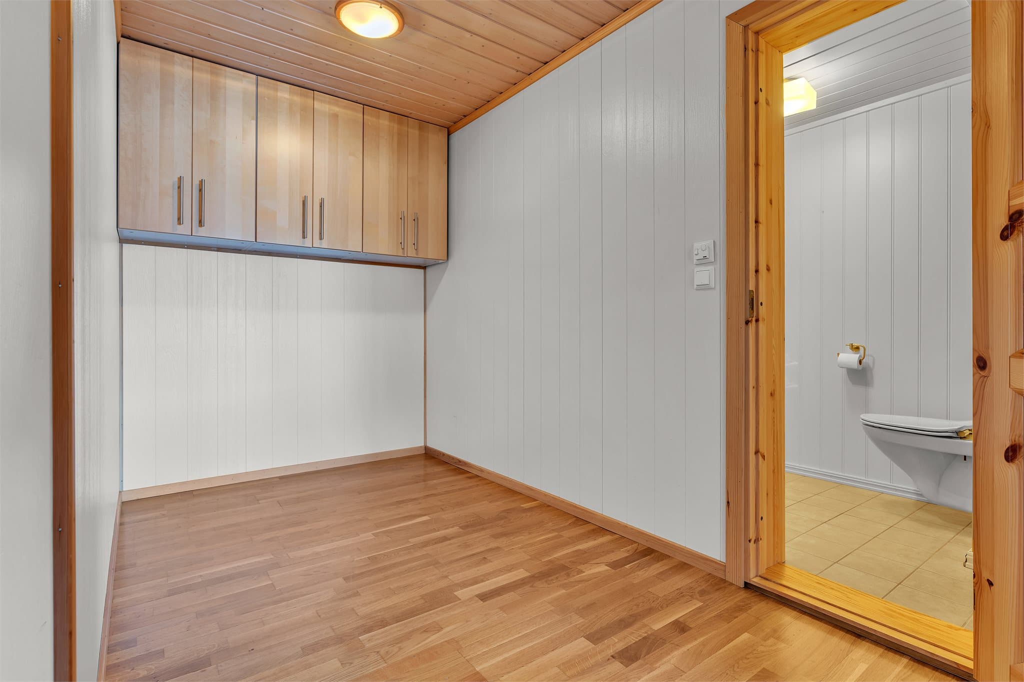 Gangareal med veggmonterte overskap for ekstra oppbevaring.