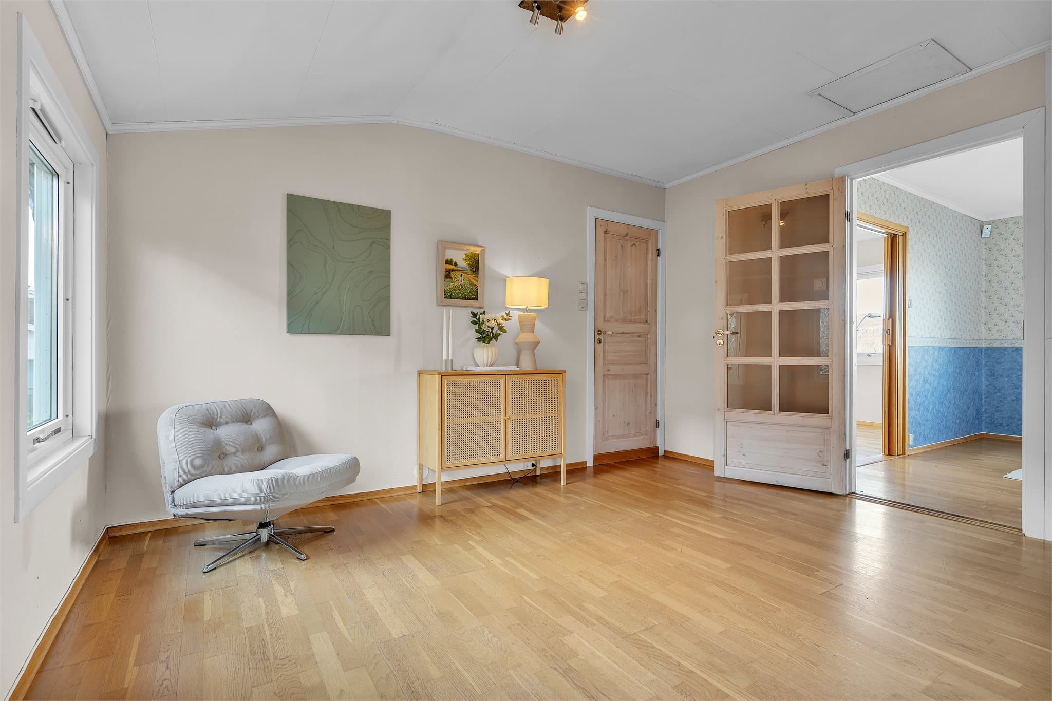 Hall med profilerte tredører fører til etasjens øvrige rom og trappegang.